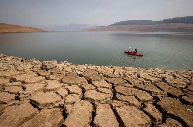<p>A kayaker in Lake Oroville as water levels remain low due to continuing drought conditions </p>