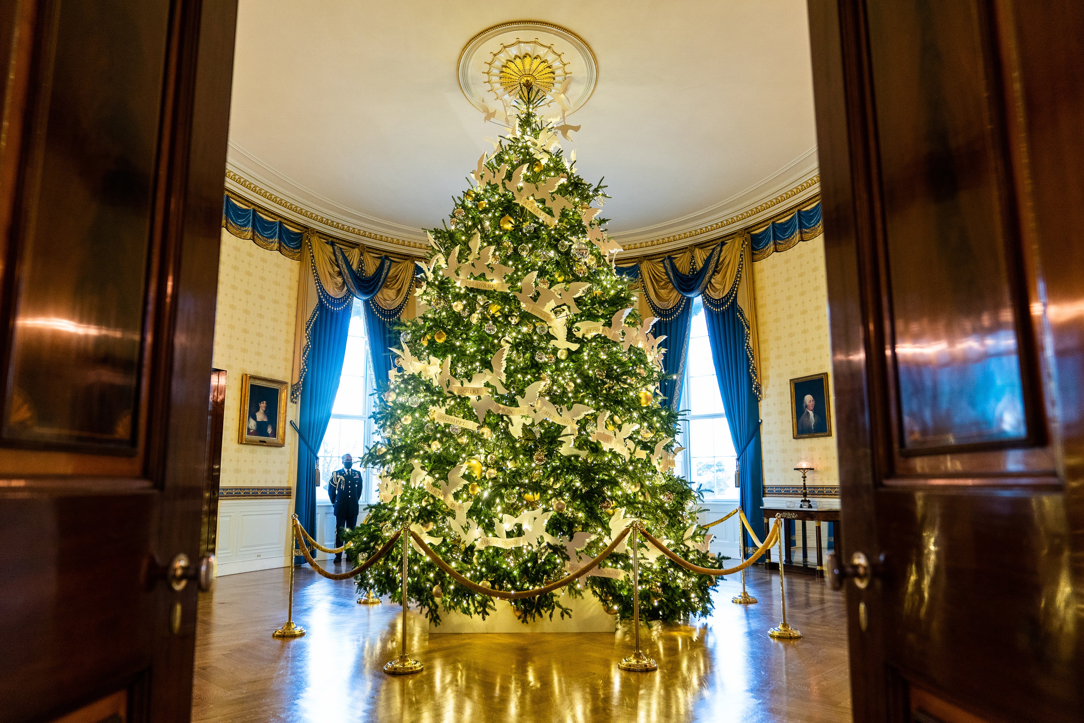 The White House Christmas tree is dotted with peace doves holding white ribbons bearing the name of each state
