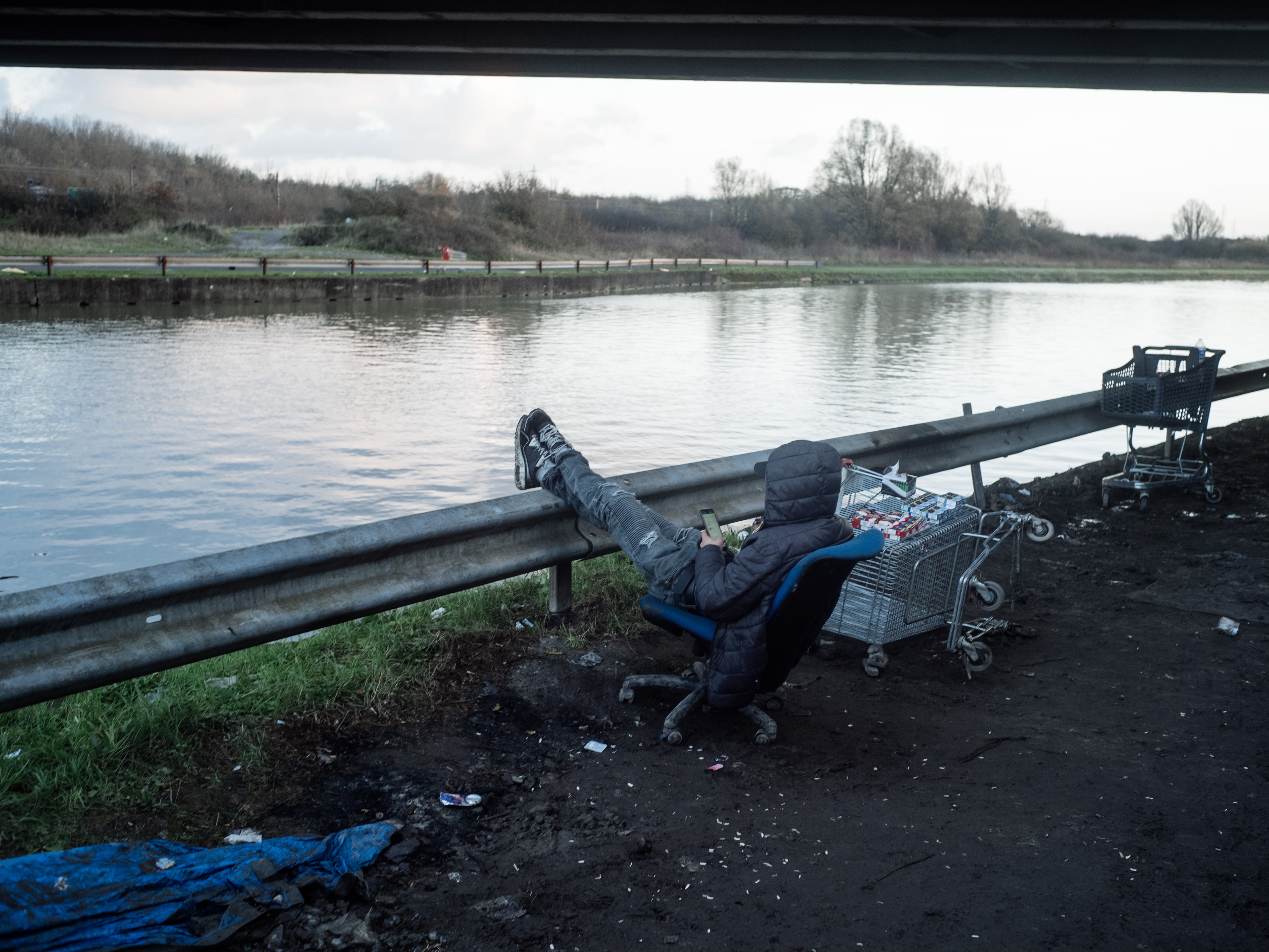 A man makes a phone call from the Grande-Synthe camp