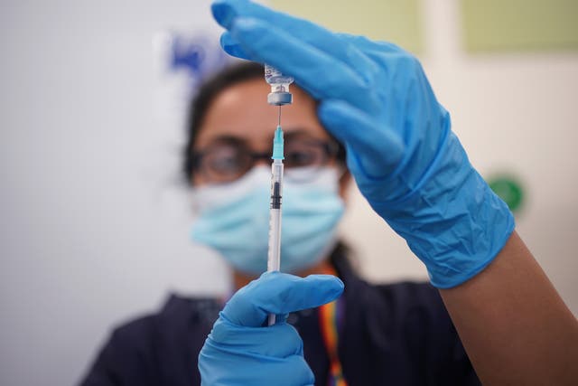 A nurse prepares a dose of the Pfizer Covid-19 vaccination at a vaccination site in Liberty Shopping Centre, Romford, east London, as the Government accelerates the Covid booster programme (Yui Mok/PA)