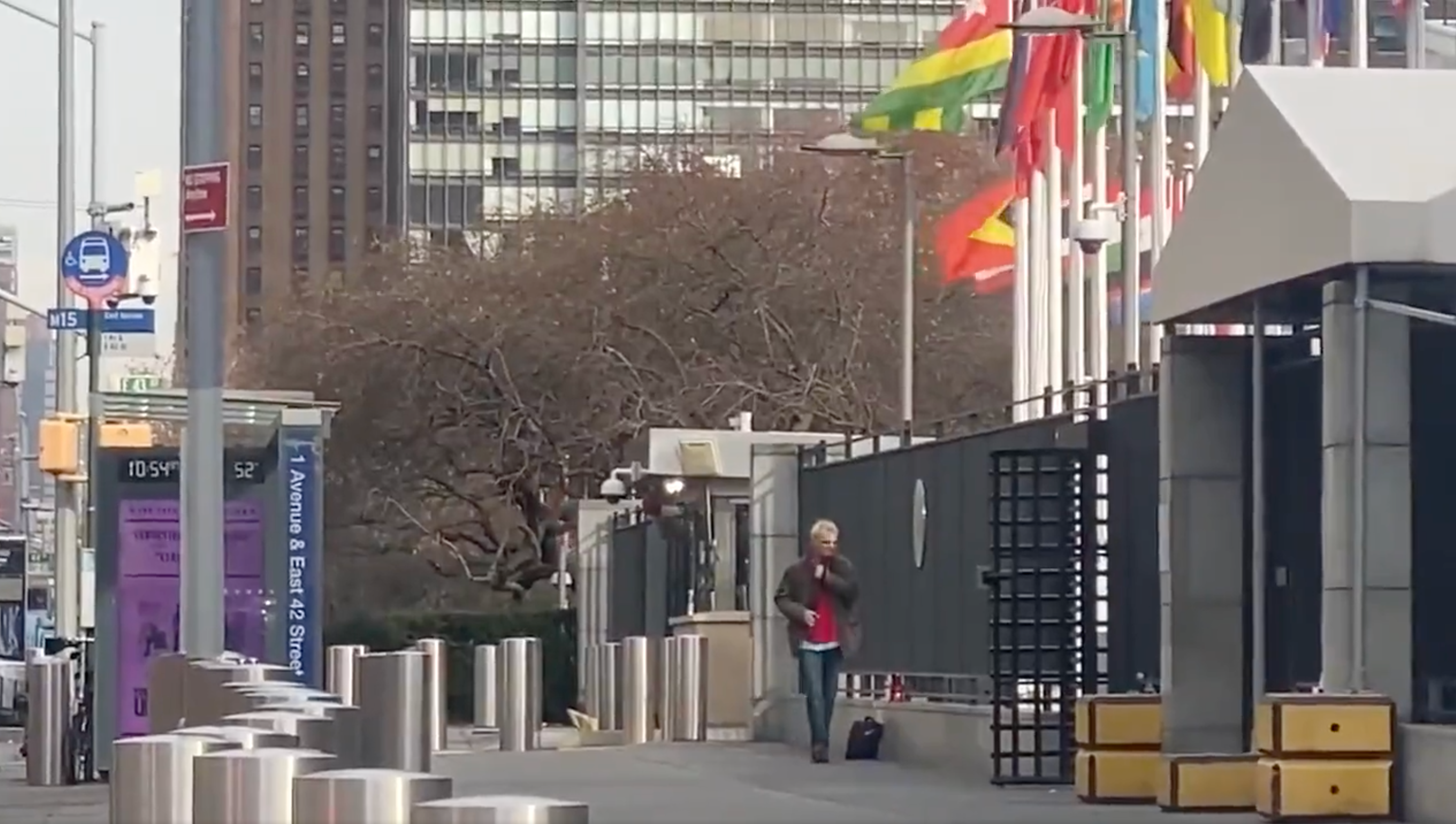 A man with what appears to be a firearm is seen pacing outside the United Nations