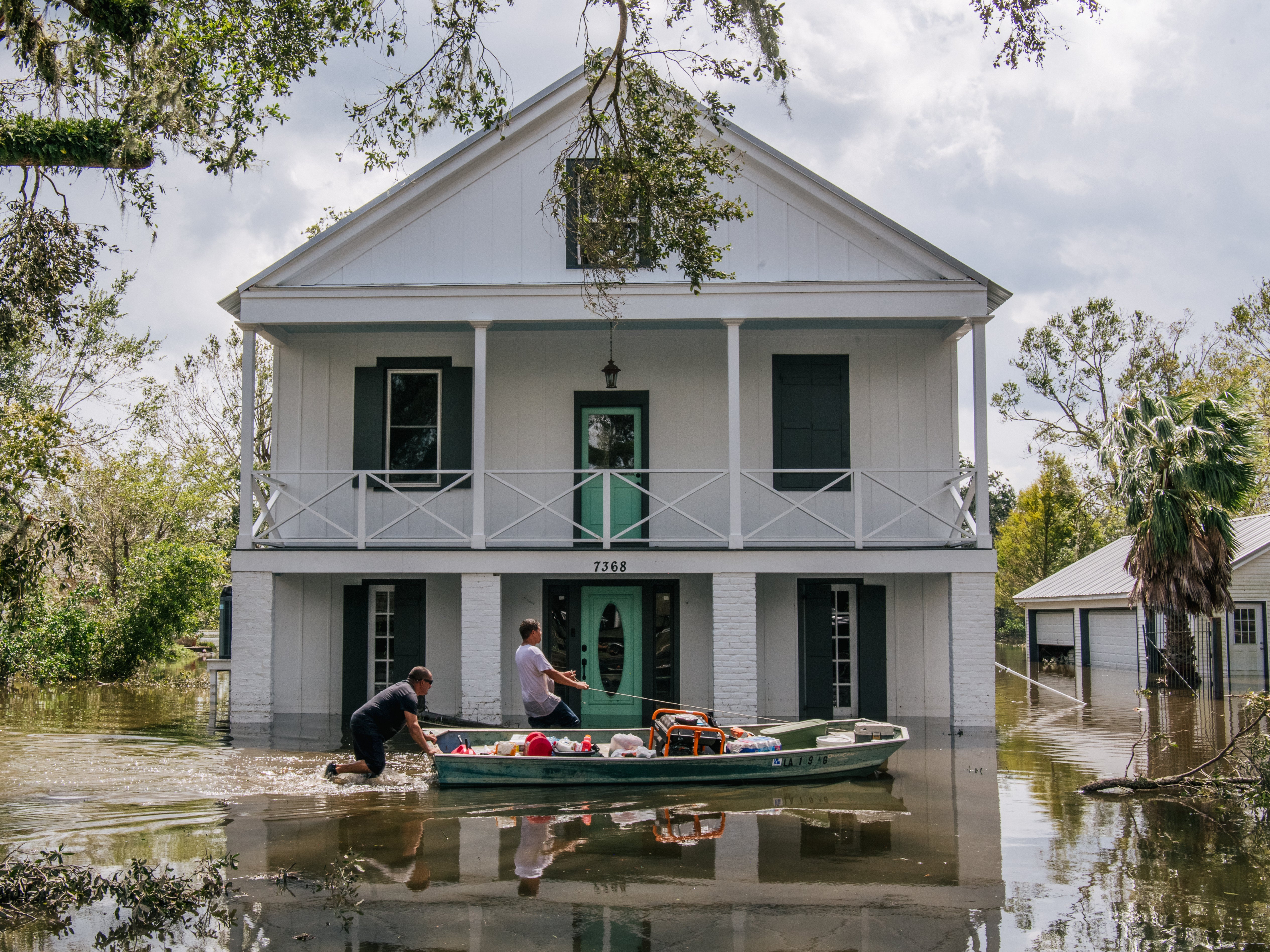 People wade through water on August 31 in Barataria, Louisiana. Hurricane Ida made landfall as a Category-4 storm in Louisiana and brought flooding and wind damage to the Gulf Coast