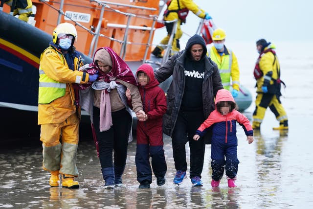 <p>A group of people thought to be migrants are brought ashore (PA)</p>