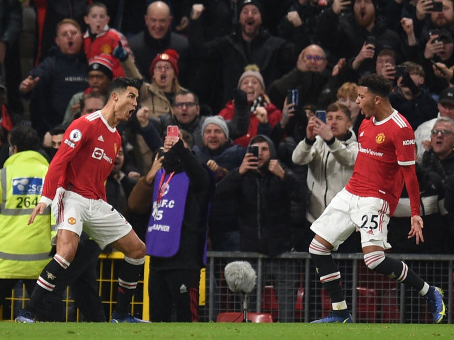 Cristiano Ronaldo celebrates scoring from the penalty spot with Jadon Sancho