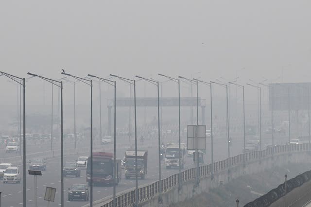 <p>People commute along a street amid smoggy conditions in India’s national capital New Delhi on 2 December 2021</p>