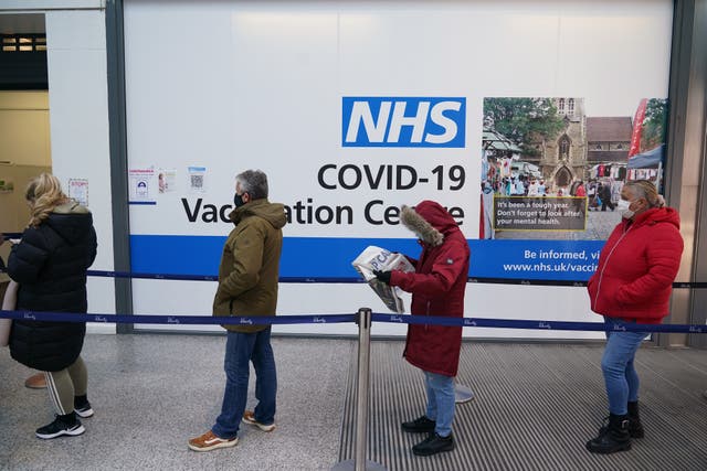 <p>People queuing to receive their Covid-19 vaccinations at a site in Liberty shopping centre, Romford, east London (Yui Mok/PA)</p>
