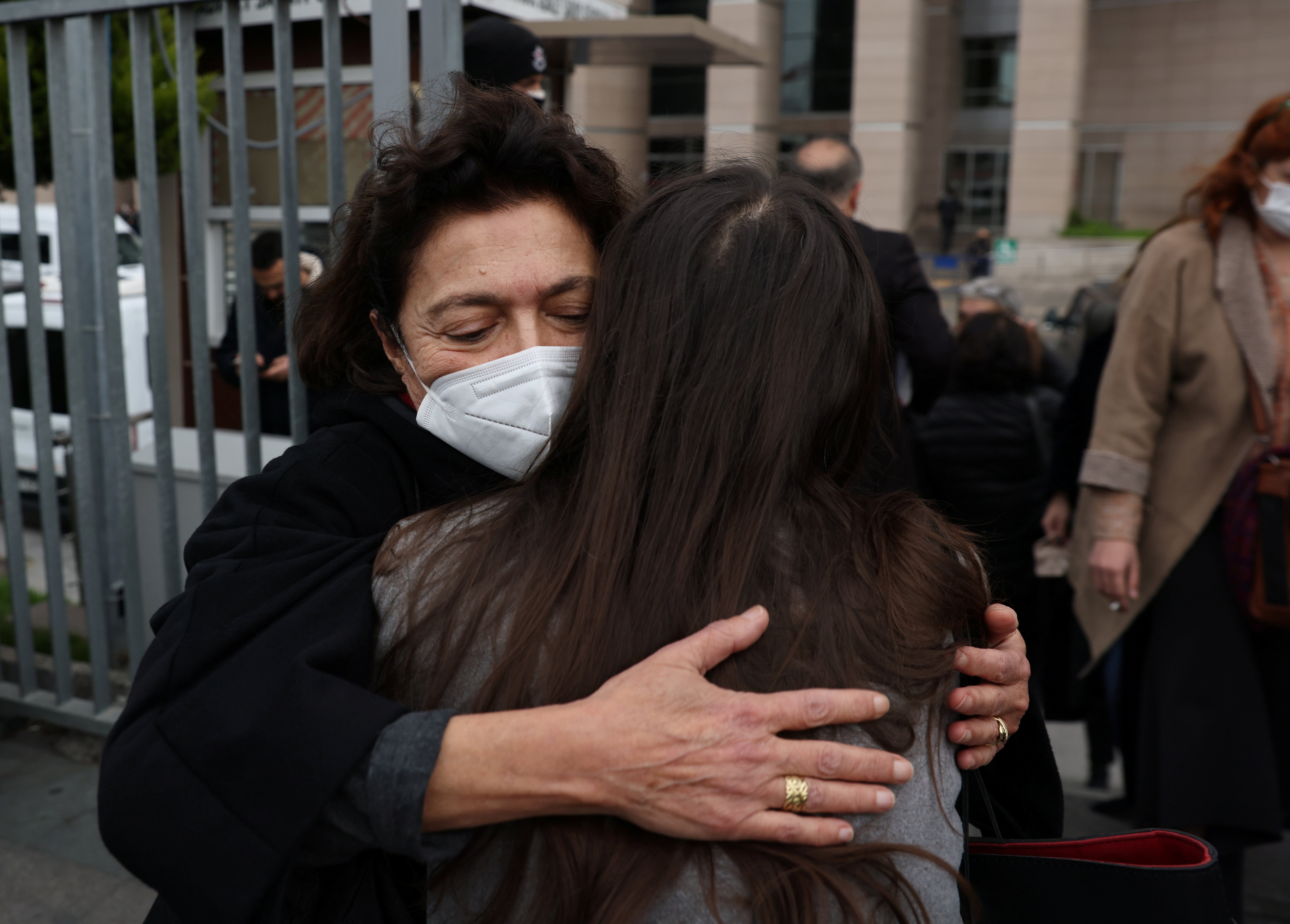 Ayse Bugra, wife of philanthropist Osman Kavala, hugs a friend as she leaves the courthouse after a hearing of Osman Kavala and 15 others over their role in nationwide protests