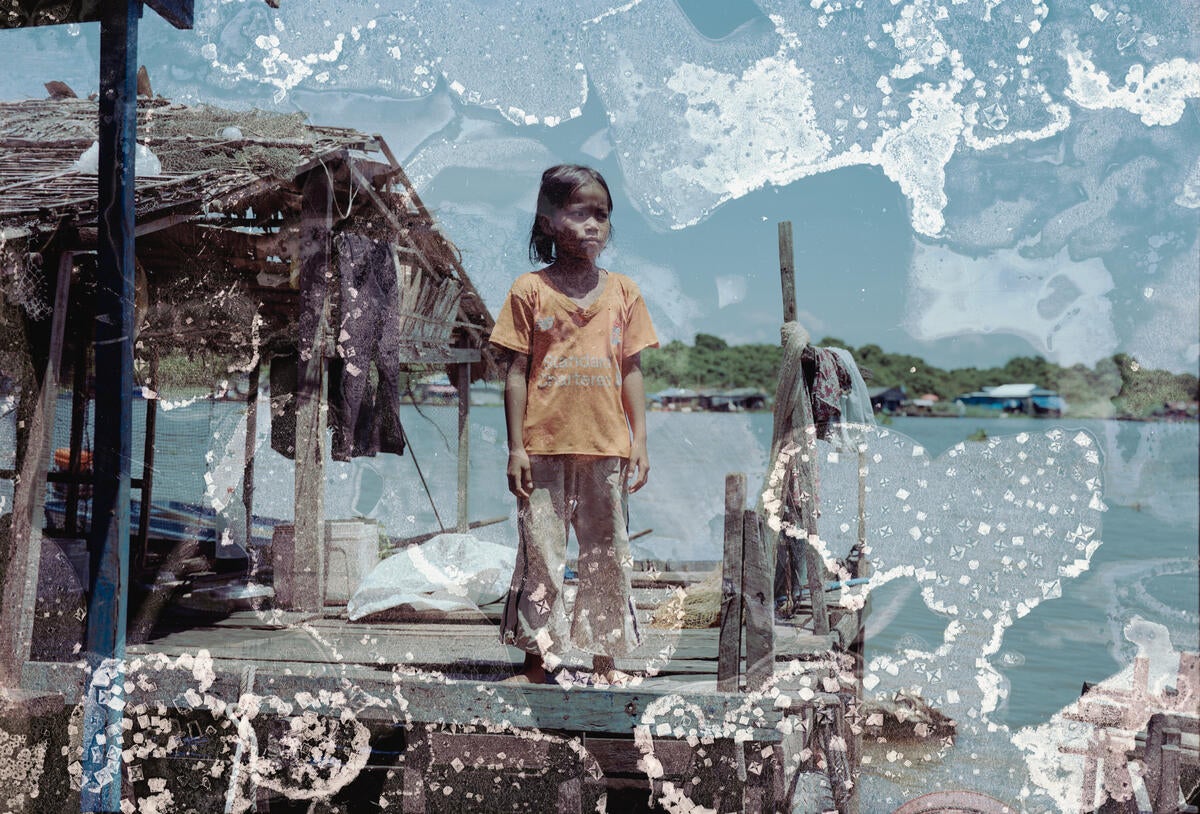 Mara, 9, standing on a fishing farm platform on Tonlé Sap lake in Cambodia