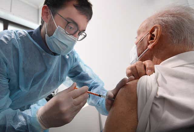 <p>A pharmacist administers the third dose of Pfizer-BioNTech COVID-19 vaccine to an elderly person in a pharmacy in Milan, northern Italy.</p>
