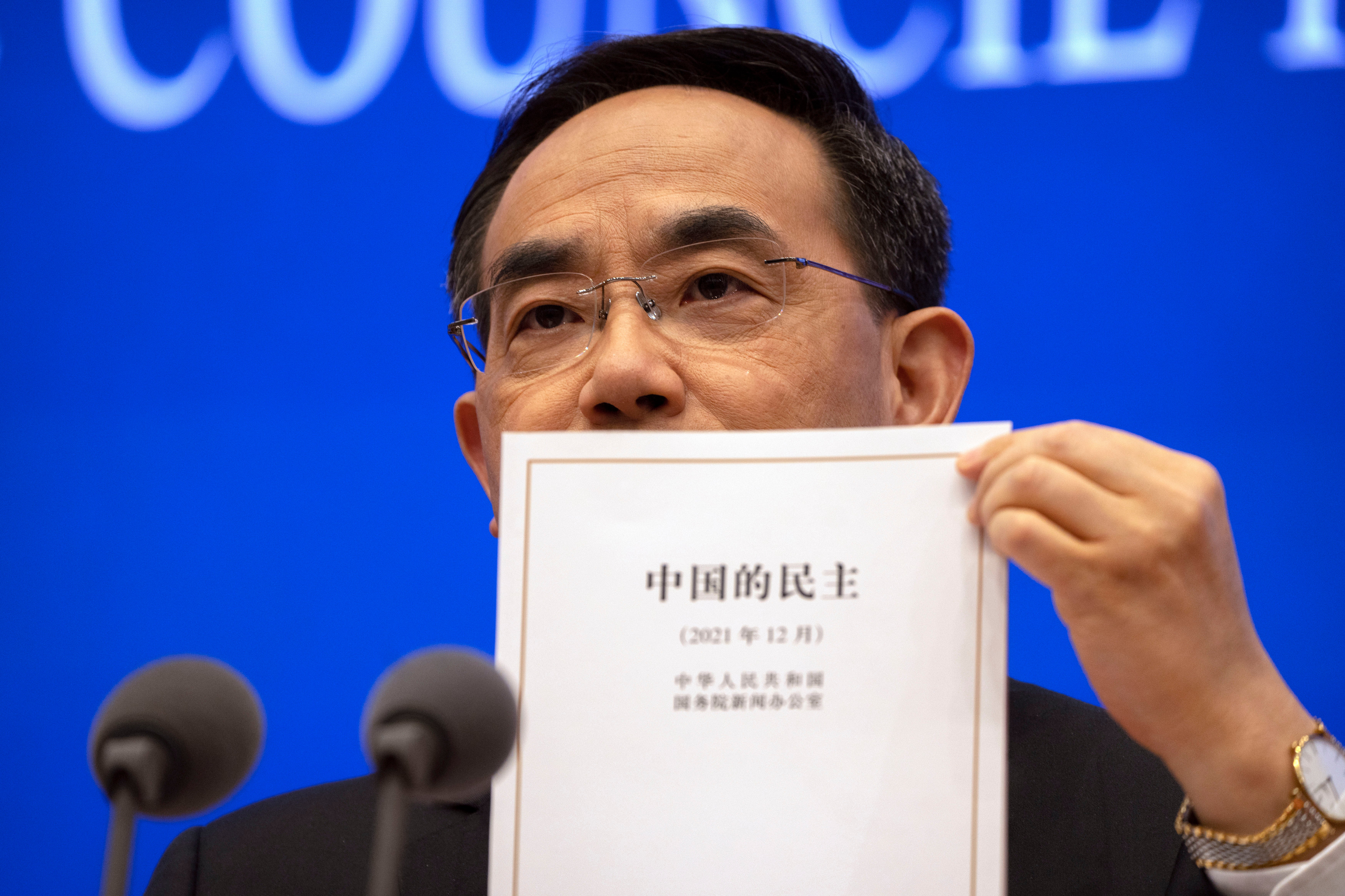 Xu Lin, vice minister of the publicity department of the central committee of China’s Communist Party holds a copy of a government-produced report titled “Democracy that Works” in Beijing on Saturday