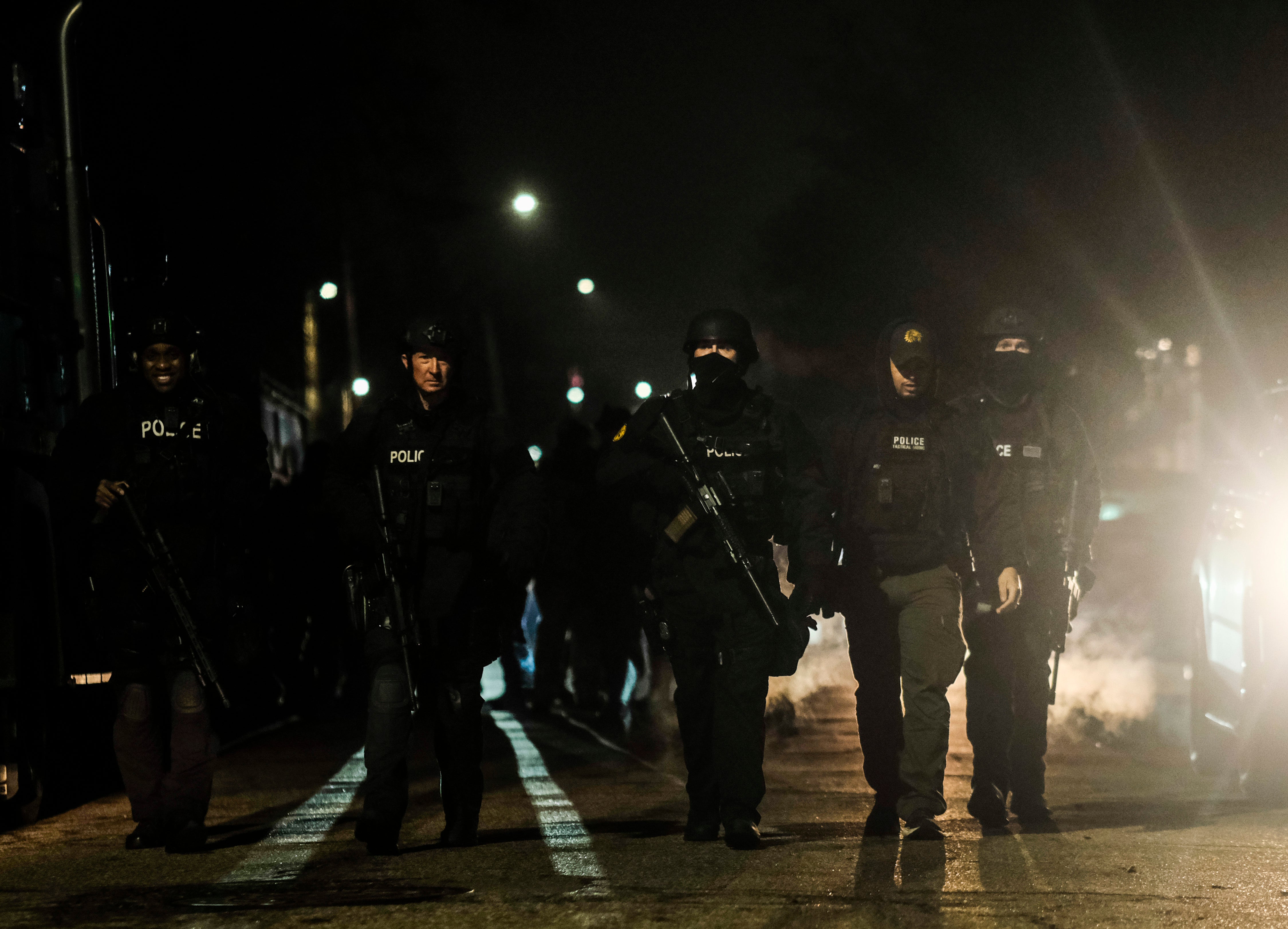 Law enforcement are seen surrounding the building in Detroit where the Crumbleys were said to be hiding