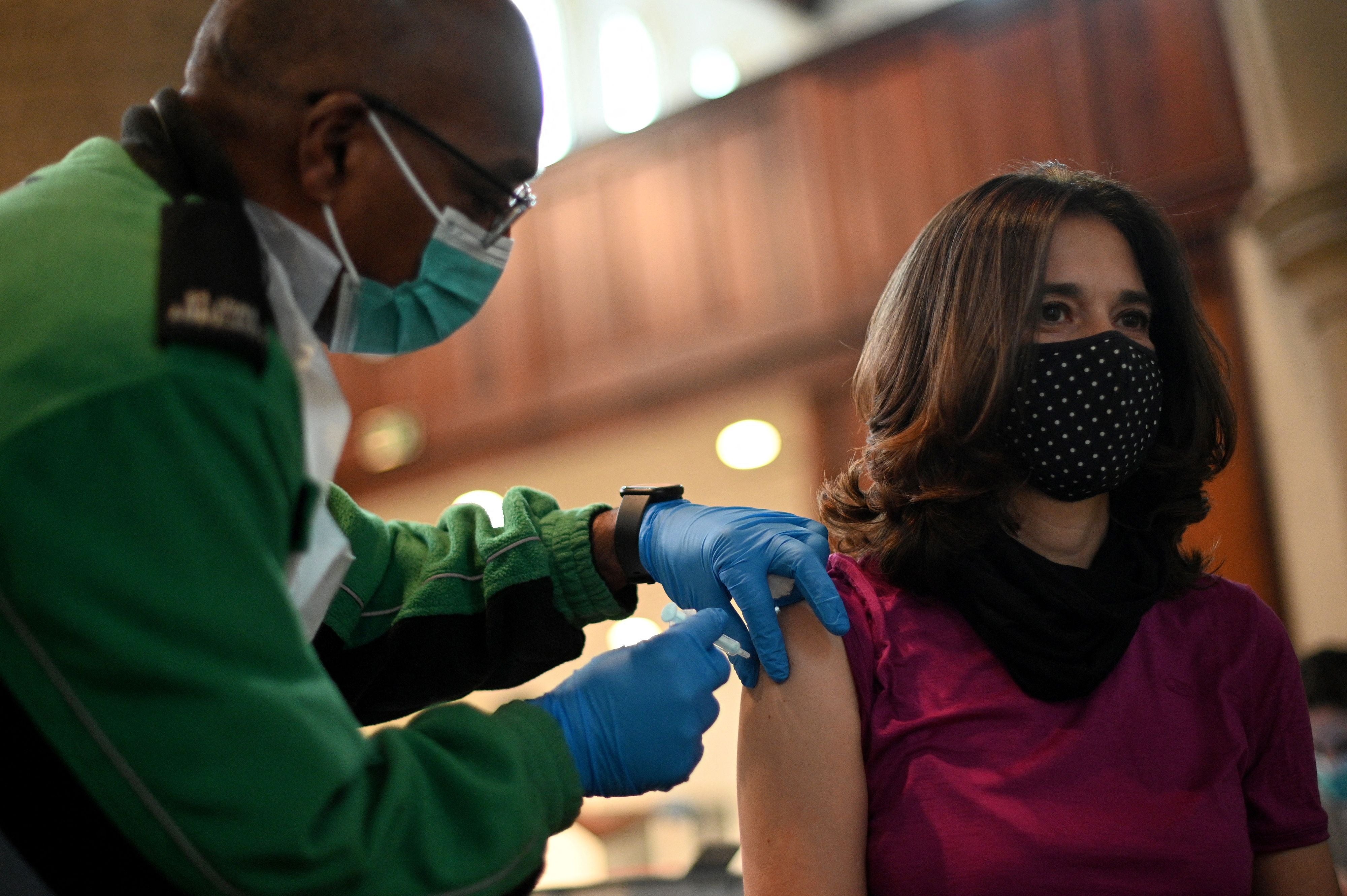 A member of the public receives a dose of a Moderna Covid-19 booster jab at a temporary vaccination centre in St John's Church in west London on 4 December