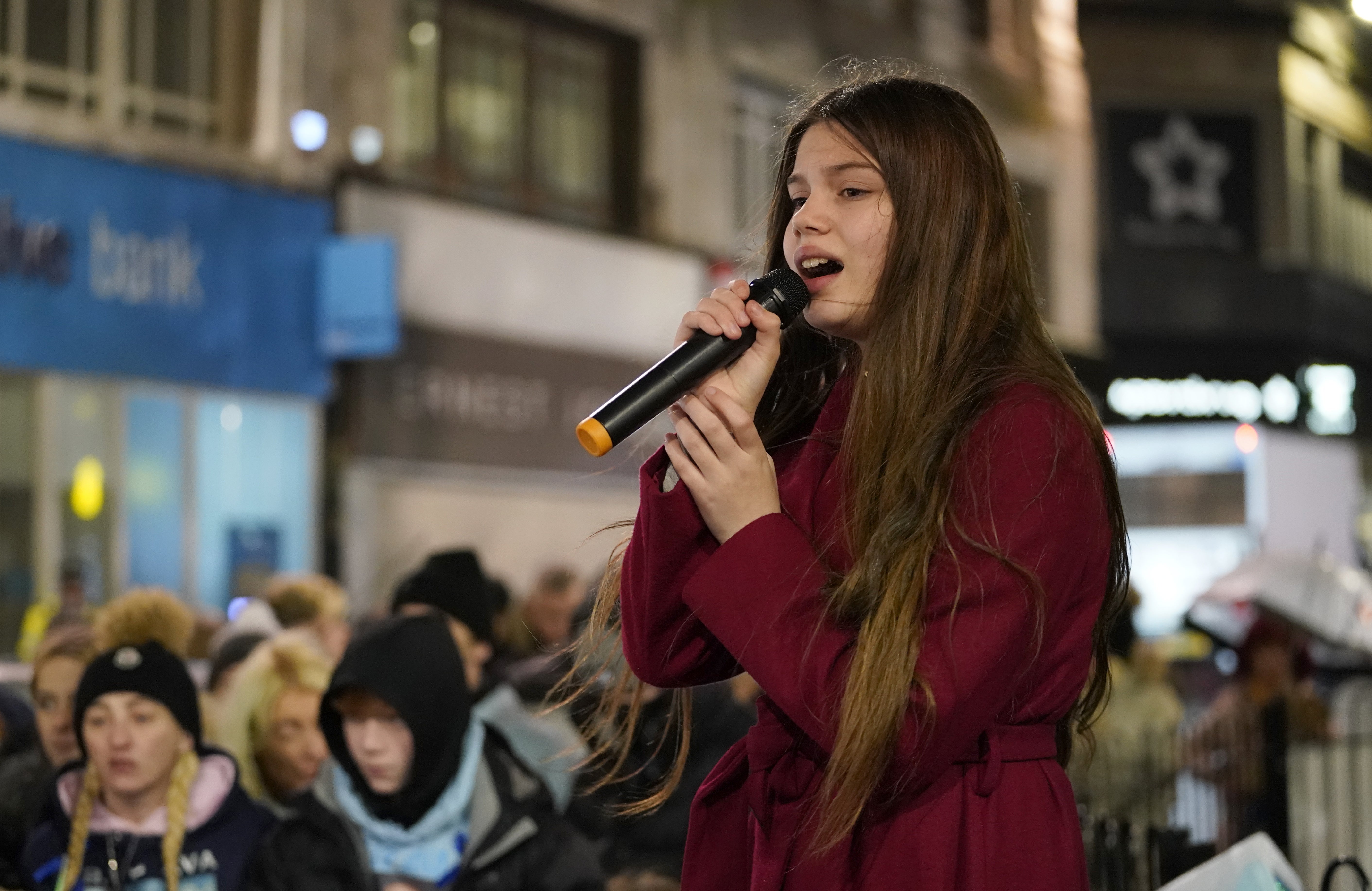 12-year-old Astrid Smith sings during the vigil (Danny LAwson/PA)