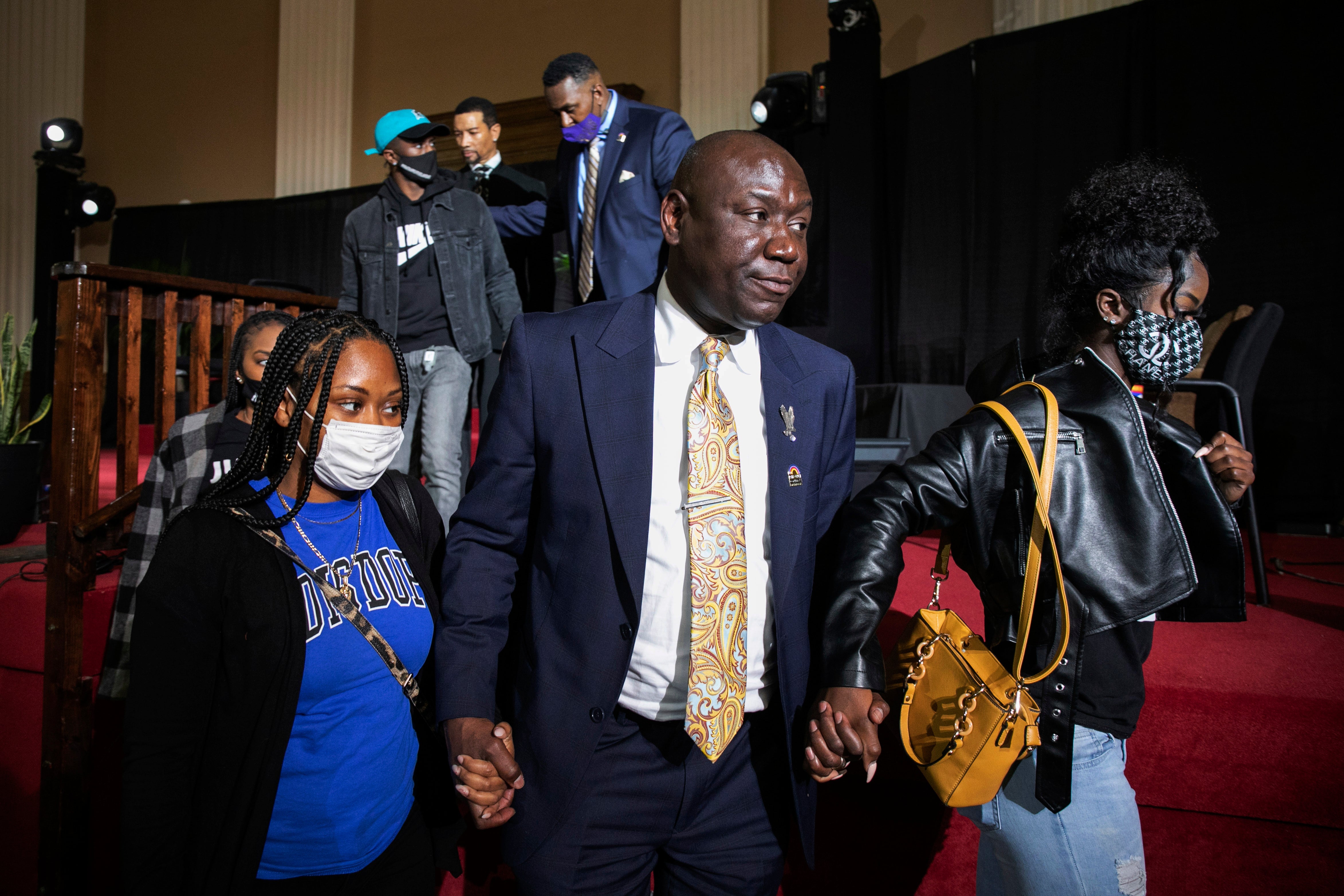 Attorney Ben Crump walks with Jelani Day's sisters Dacara Bolden (left) and Zena Day (right) at Friday’s press conference as his family call for the FBI to take the case