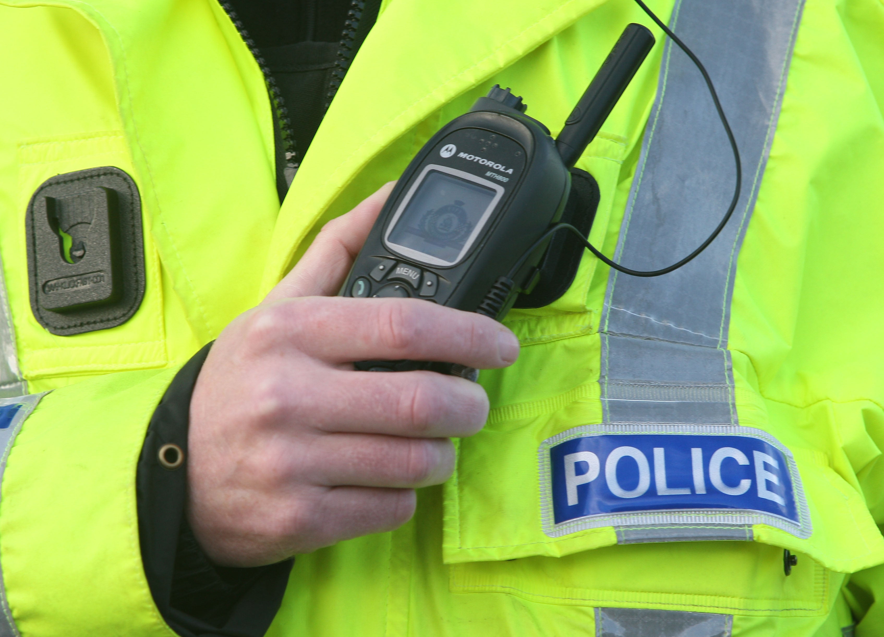 A police officer using a radio. (David Cheskin/PA)