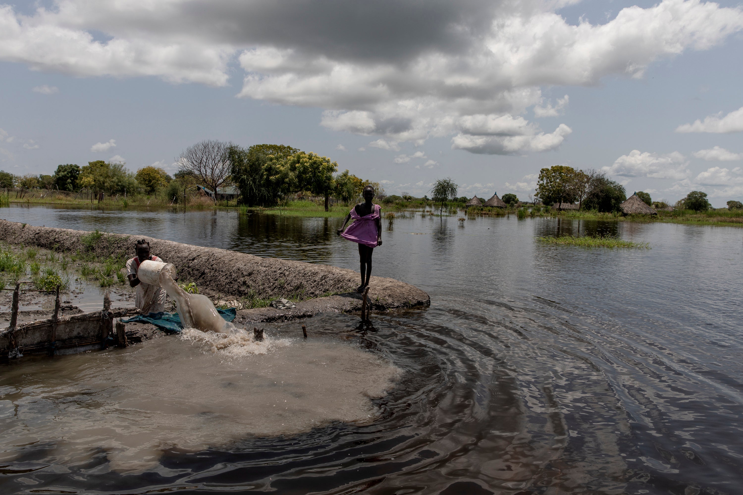 Some, like Angelina Nyajany Wan, choose to stay and build dykes to try to keep water out of their homes