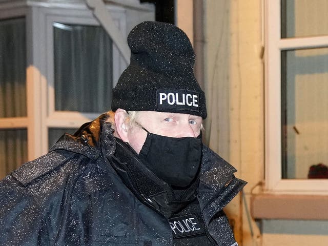 <p>Johnson dresses in police gear as he observes an early morning raid by Merseyside Police</p>