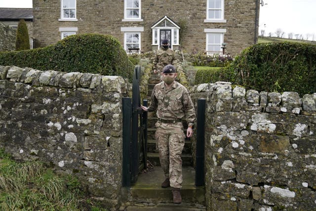 Sergeant Jon Bott (front) and Craftsman Emily Heaviside of the Royal Lancers carry out a welfare check at a property in the Weardale Valley, County Durham (Danny Lawson/PA)
