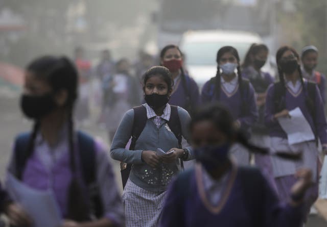 <p>File: School girls walk amid heavy smog during India’s air pollution season in November </p>