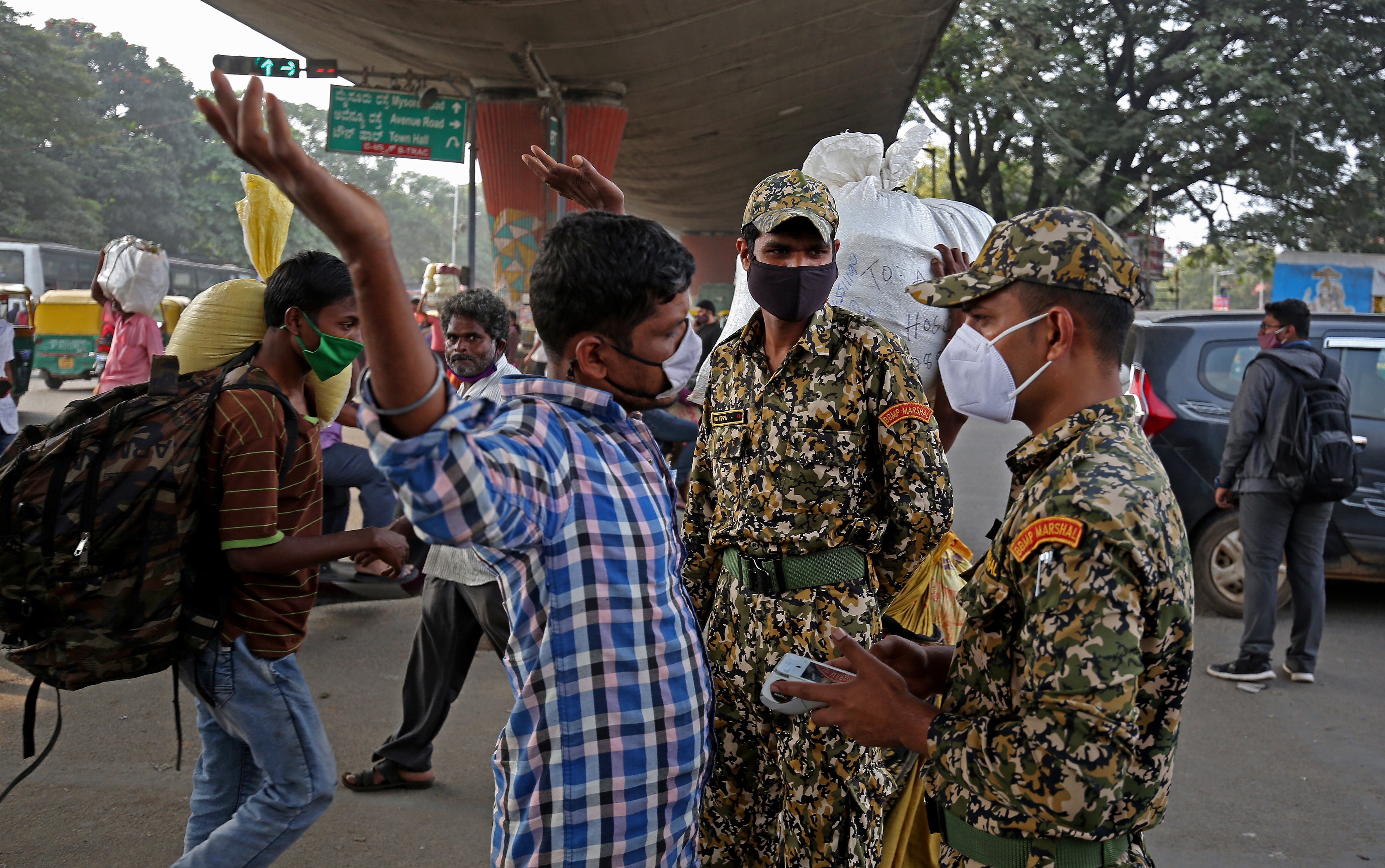 Marshals patrol the area looking for people not wearing a mask amid the ongoing pandemic in Karnataka state capital Bengaluru, where a case of the omicron variant was detected
