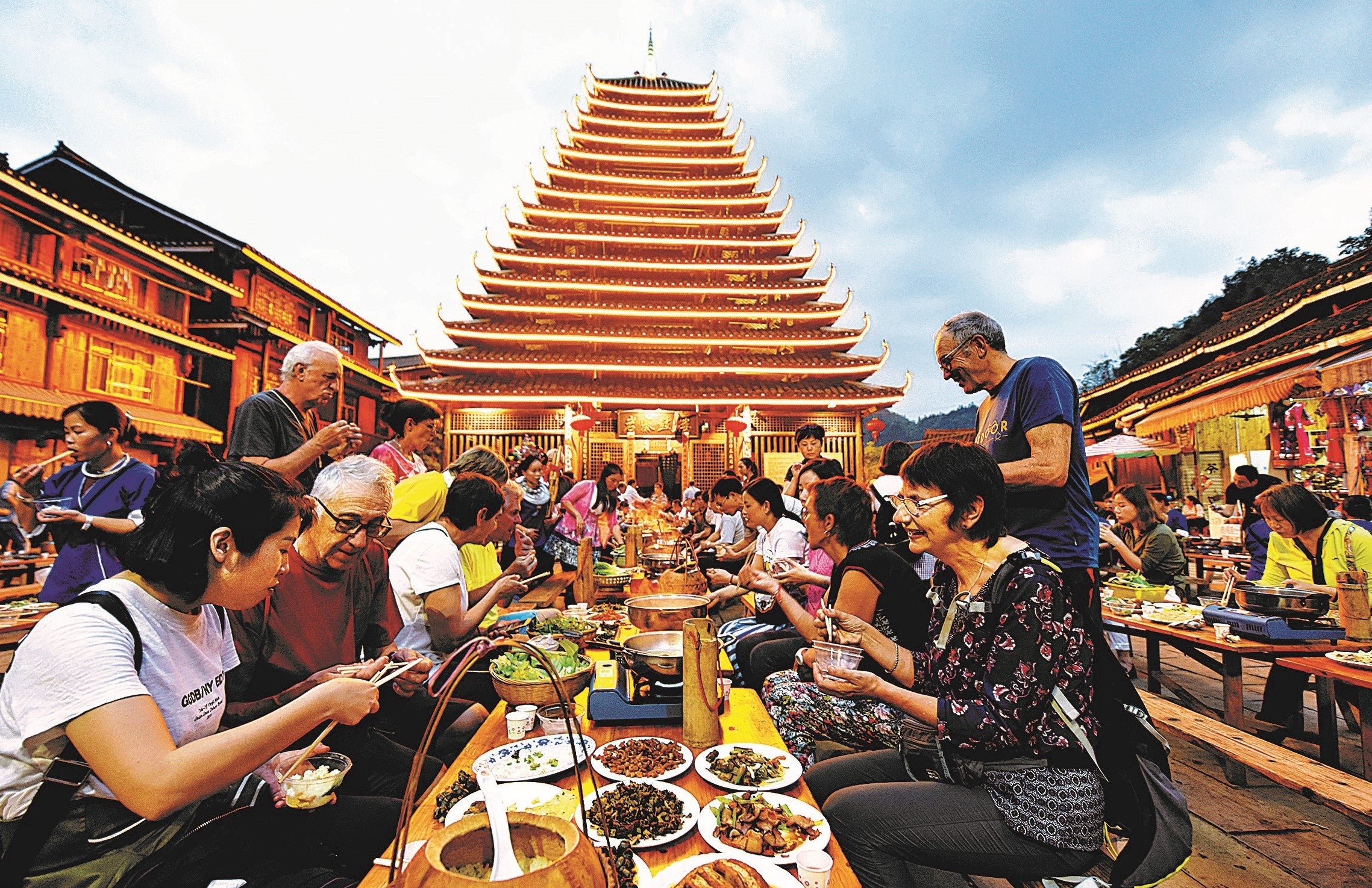 Tourists from home and abroad enjoy traditional Dong food during a festival banquet in April 2019