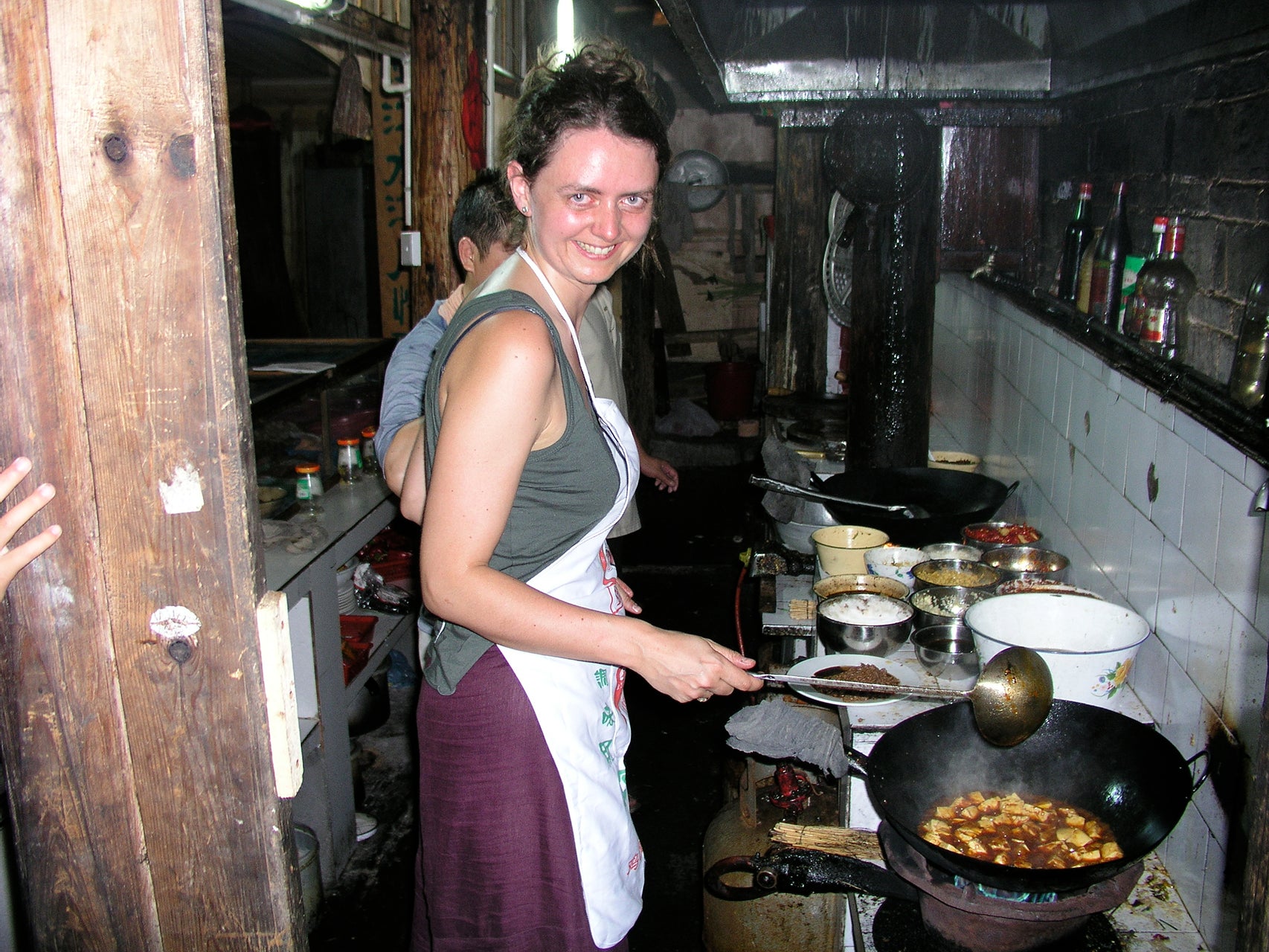 Fuchsia Dunlop cooks Mapo tofu, stir-fried tofu in hot sauce, in the kitchen of a restaurant in Fenghuang ancient town in western Hunan province.
