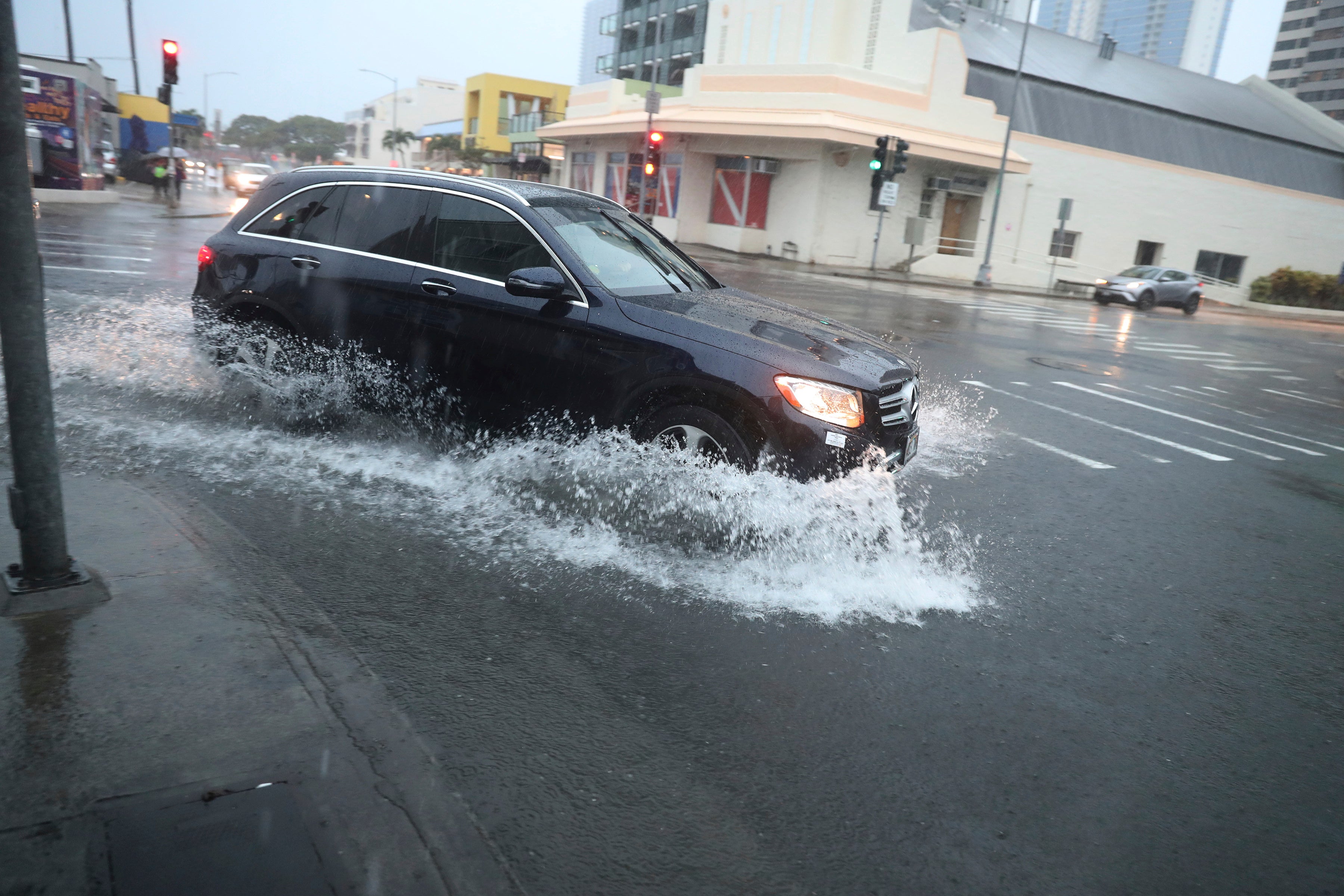 A car turns onto a flooded street on Monday, December 6 in Honolulu