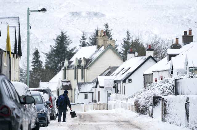 A man clears snow in Leadhills, South Lanarkshire as Storm Barra hits the UK and Ireland with disruptive winds, heavy rain and snow (PA)