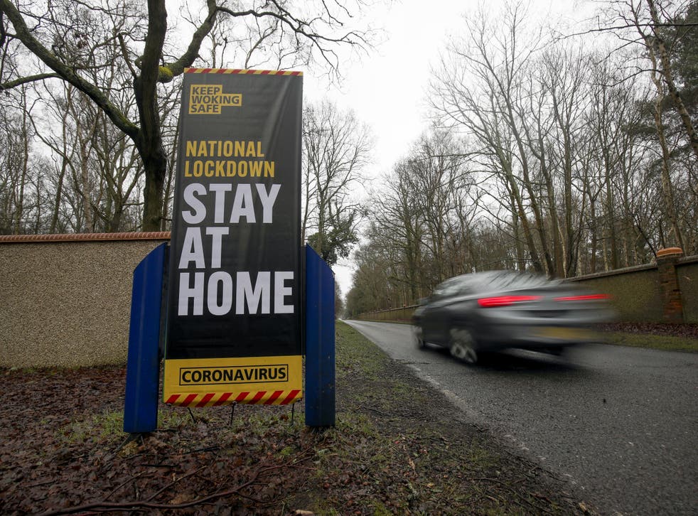 A car drives past a coronavirus information sign in Brookwood, Surrey, during the second wave of Covid-19 in January 2021 (Steve Parsons/PA)