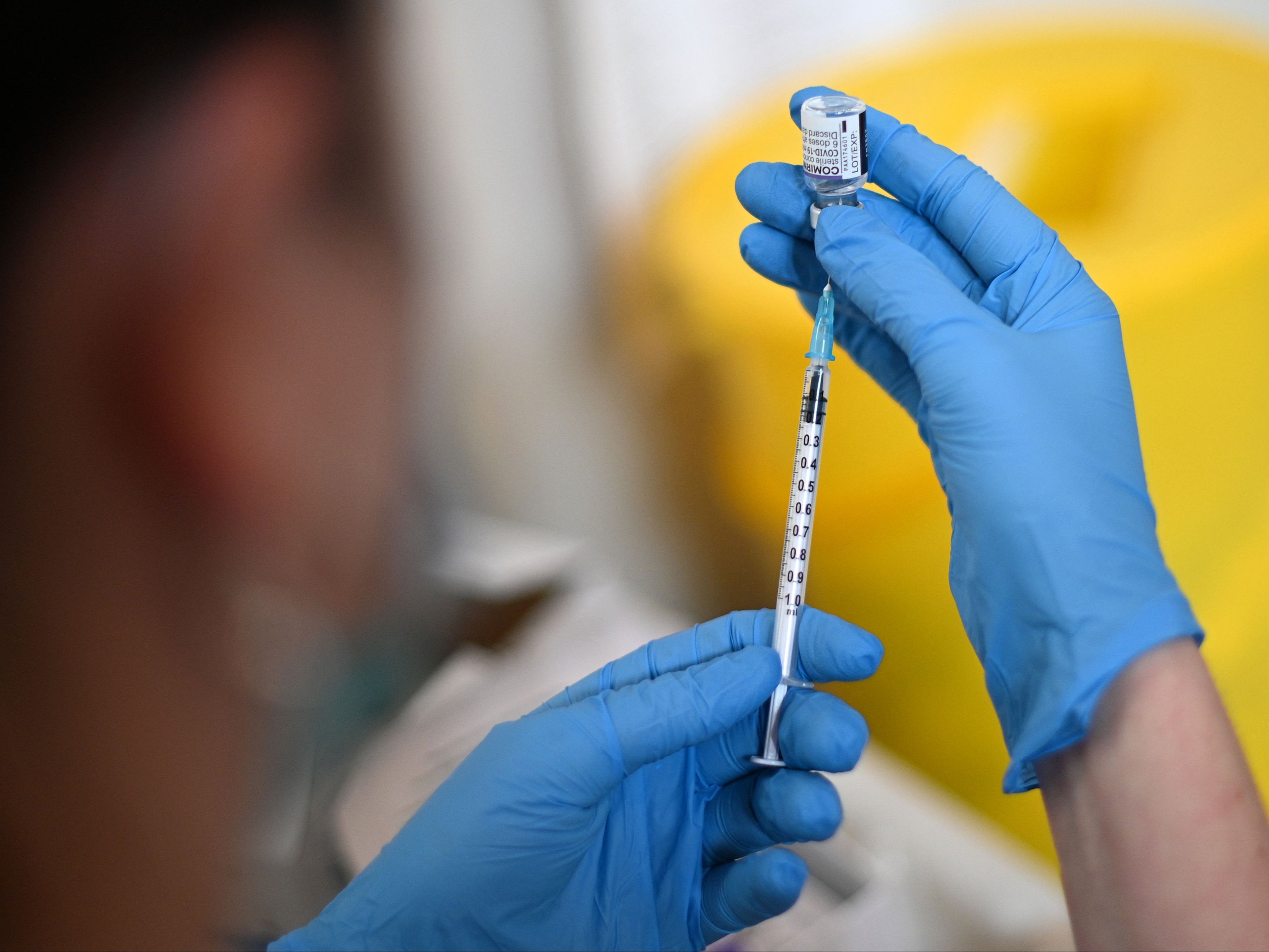A clinician prepares a dose of the Pfizer vaccine at a vaccination centre in west London