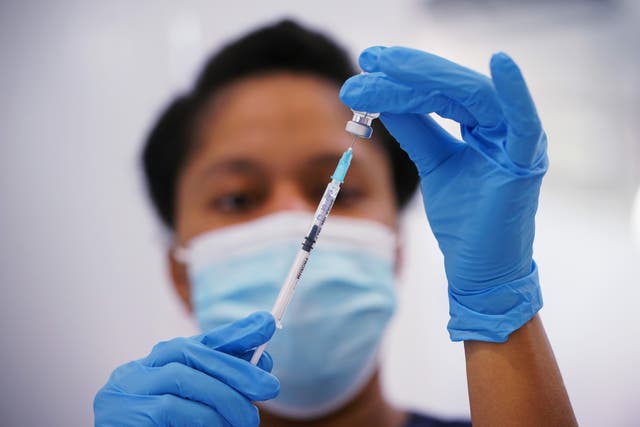 A nurse prepares a dose of the Pfizer Covid-19 vaccination at a vaccination site in Liberty Shopping Centre, Romford, east London (Yui Mok/PA)