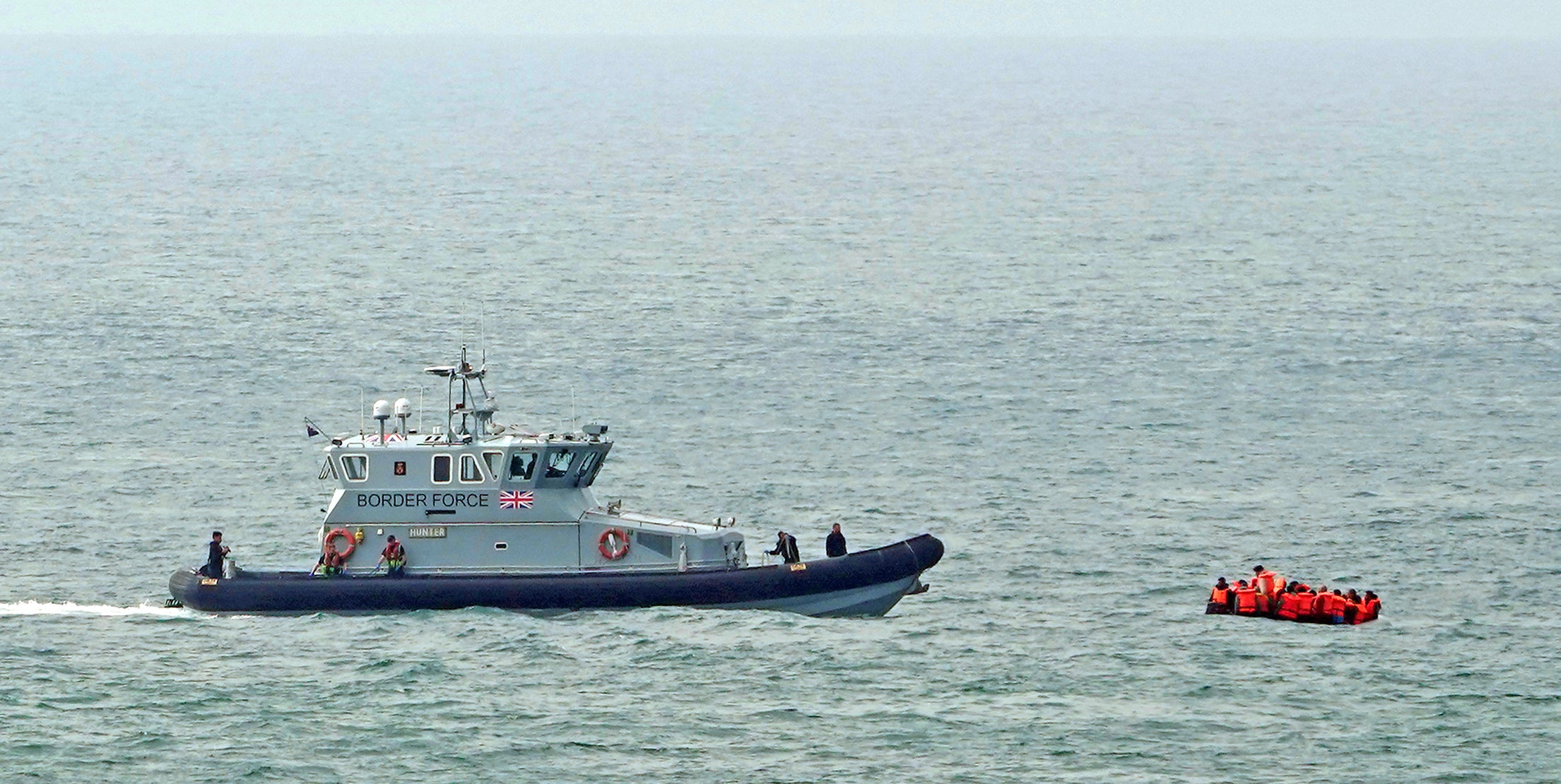 A Border Force vessel approaches a group of people in the Channel (Gareth Fuller/PA)
