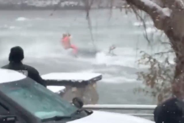 <p>A member of the US Coast Guard swings on a wire onto a car that is submerged in the icy Niagara River near the edge of the American Falls in New York. The rescuer recovered the body of a 66-year-old woman from the vehicle.</p>