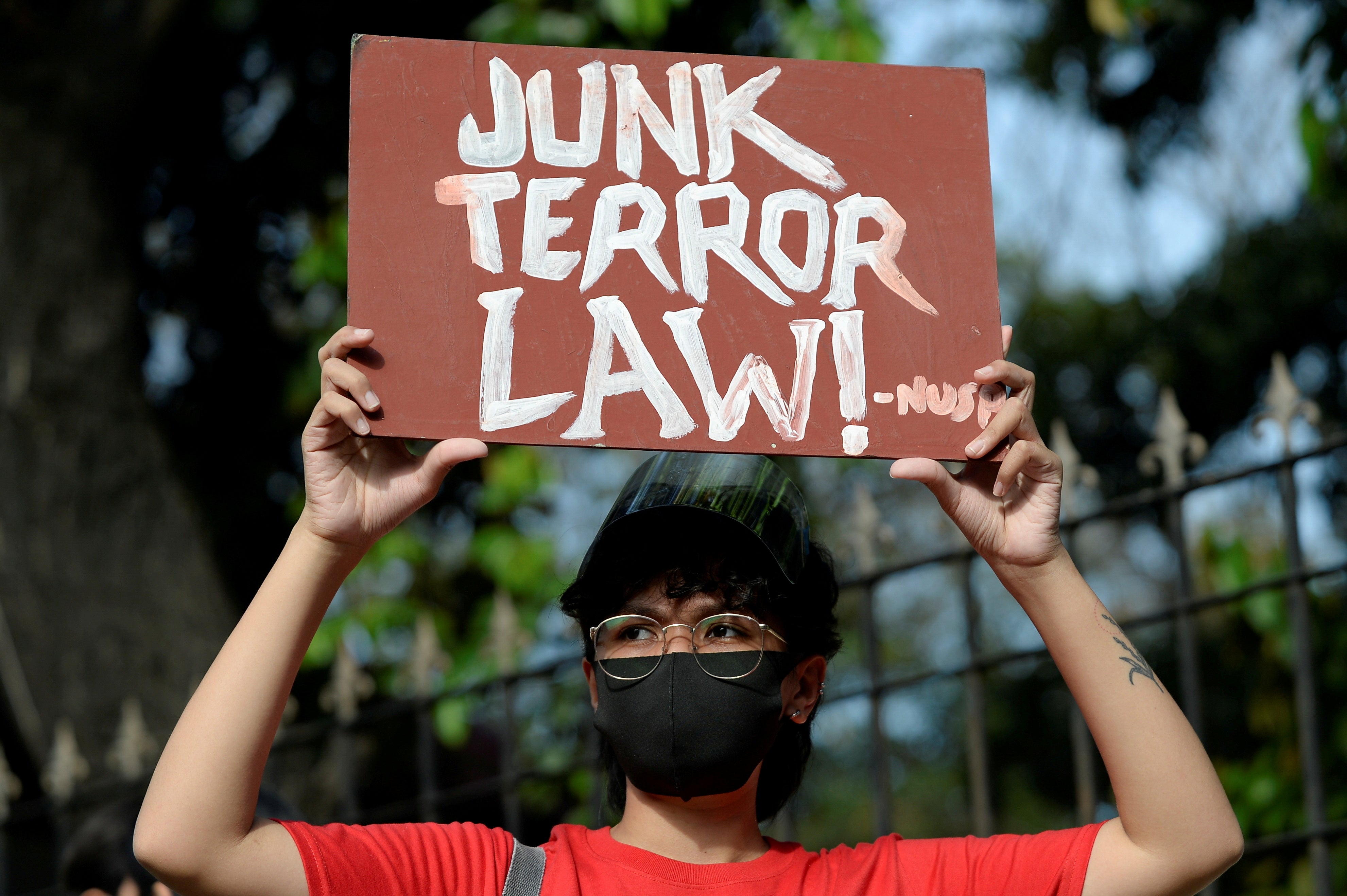 An activist holds a placard at a protest prior to the hearing of oral arguments on the anti-terrorism law