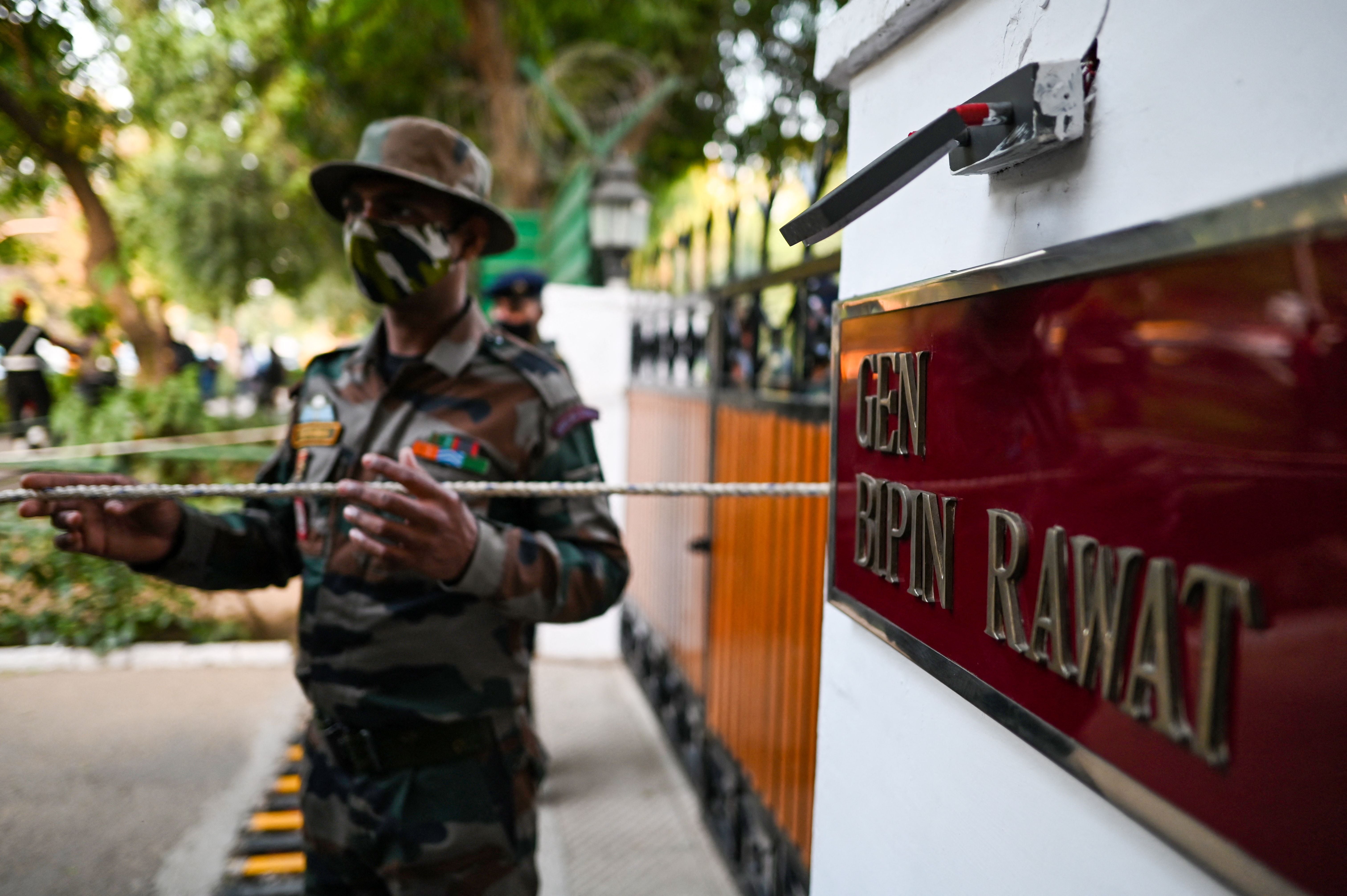 Security personnel stand guard outside the entrance of defence chief General Bipin Rawat's house in New Delhi on 8 December, 2021