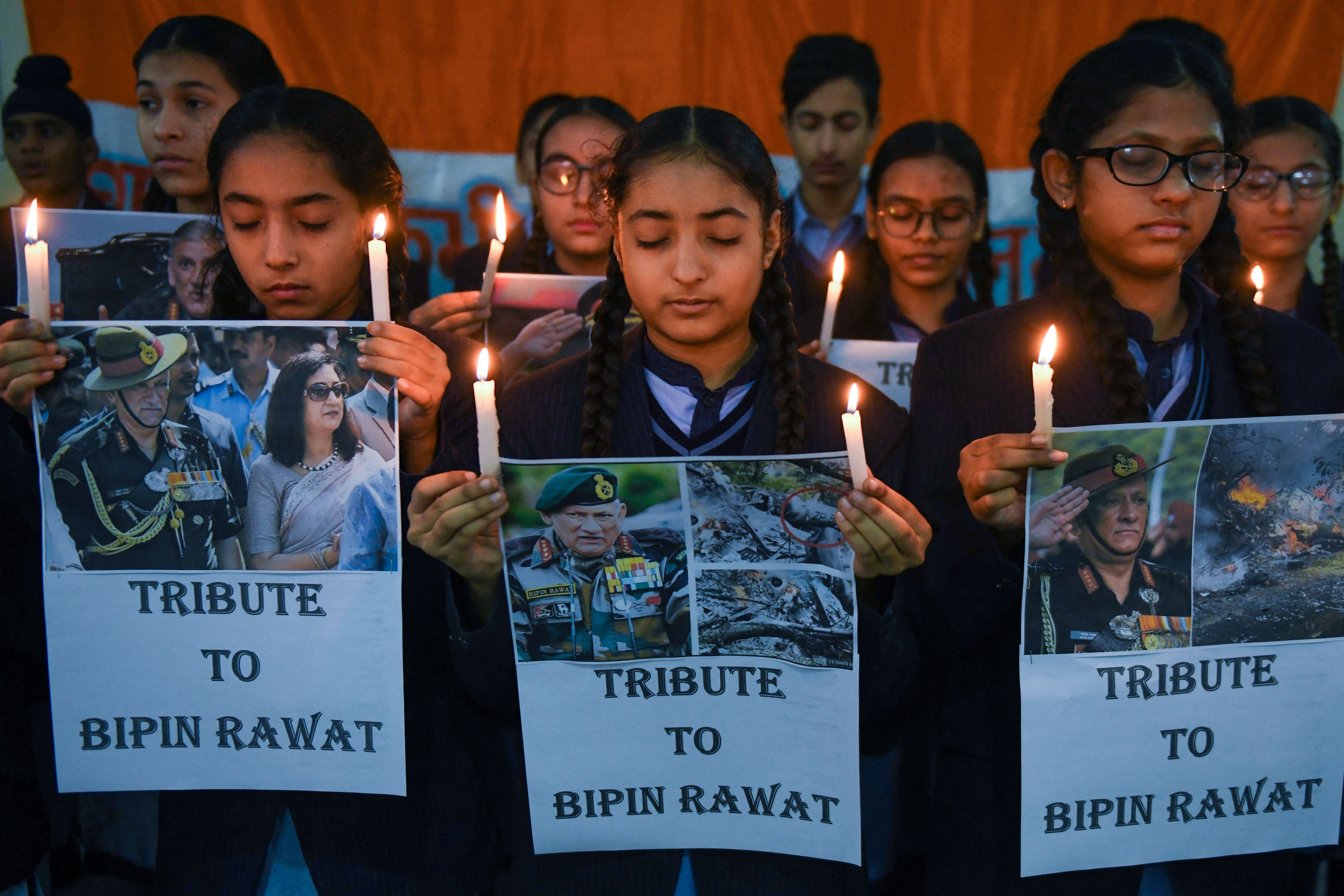 Students hold light candles and posters to pay their tribute to India’s defense chief General Bipin Rawat, who was killed with 13 others a day earlier in a helicopter crash