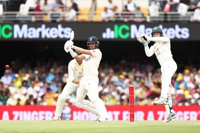 England’s Dawid Malan (left) plays a shot as Australia’s Alex Carey looks on during day three of the first Ashes test at The Gabba, Brisbane (Jason O’Brien/PA)