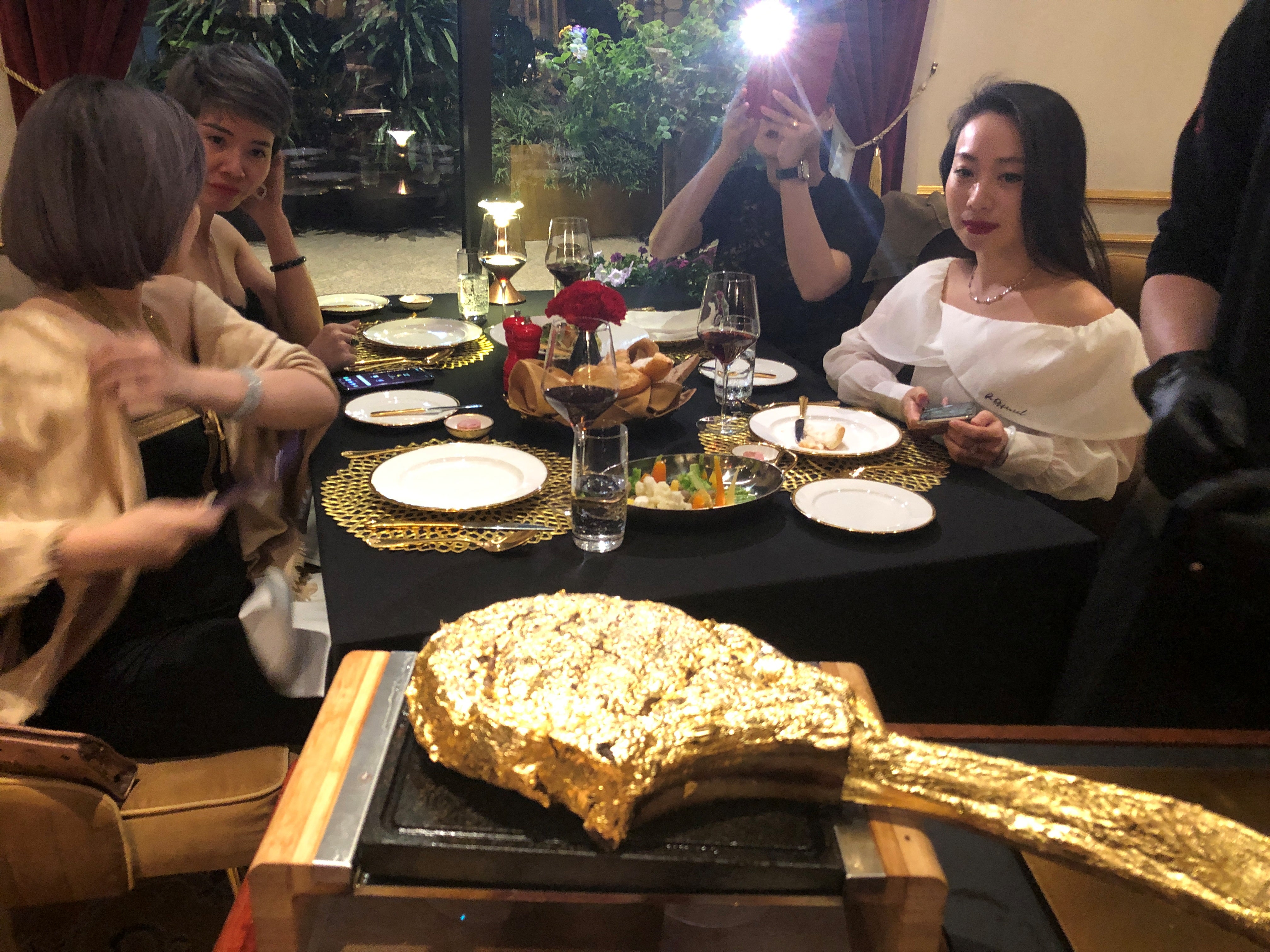 A customer takes pictures of a gold leaf-coated steak at the Dolce By Wyndham Hanoi Golden Lake hotel in Hanoi