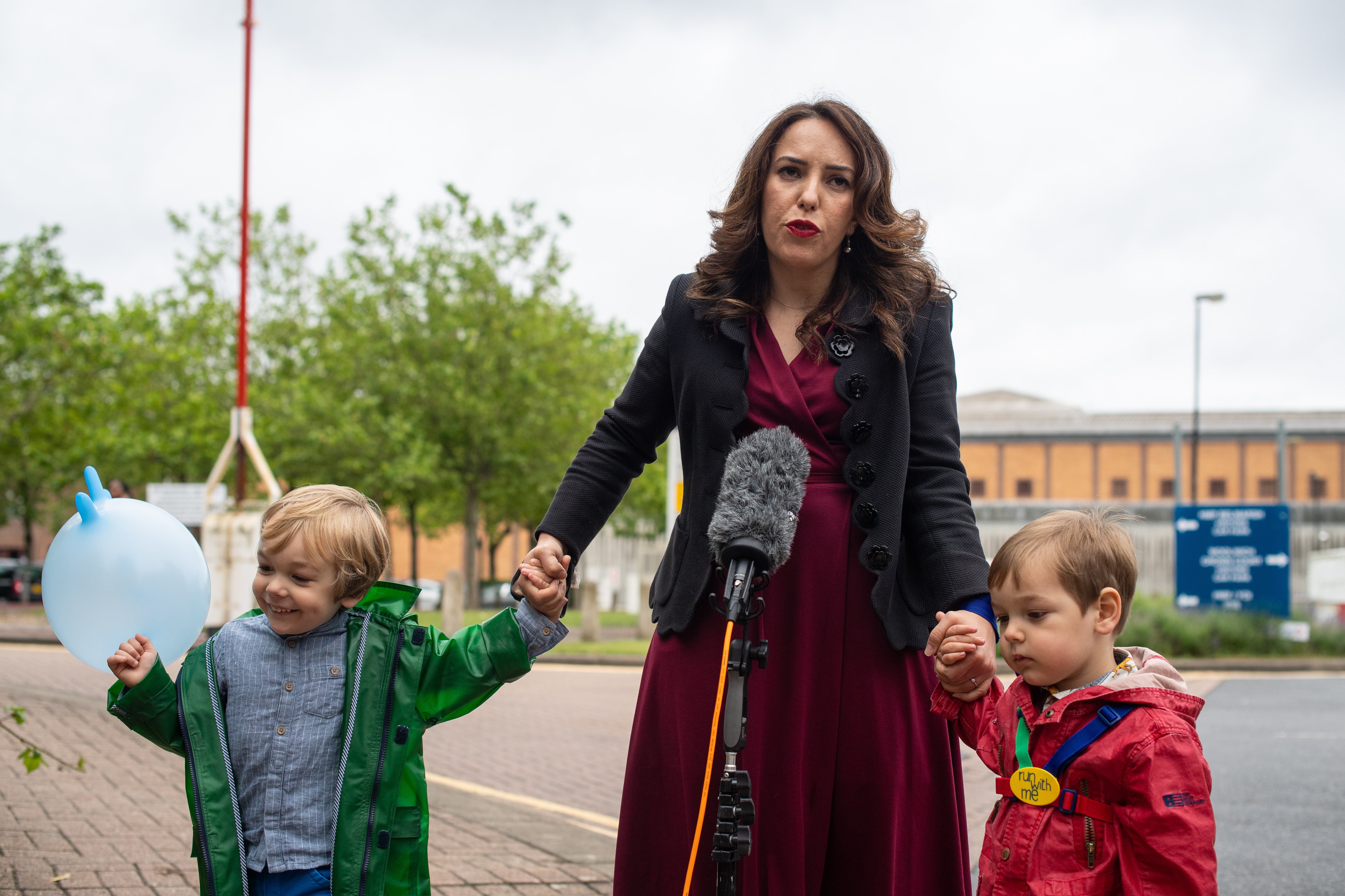 Stella Moris stands with her children Gabriel and Max as she speaks to the media outside Belmarsh Prison in 2021 (Dominic Lipinski/PA)