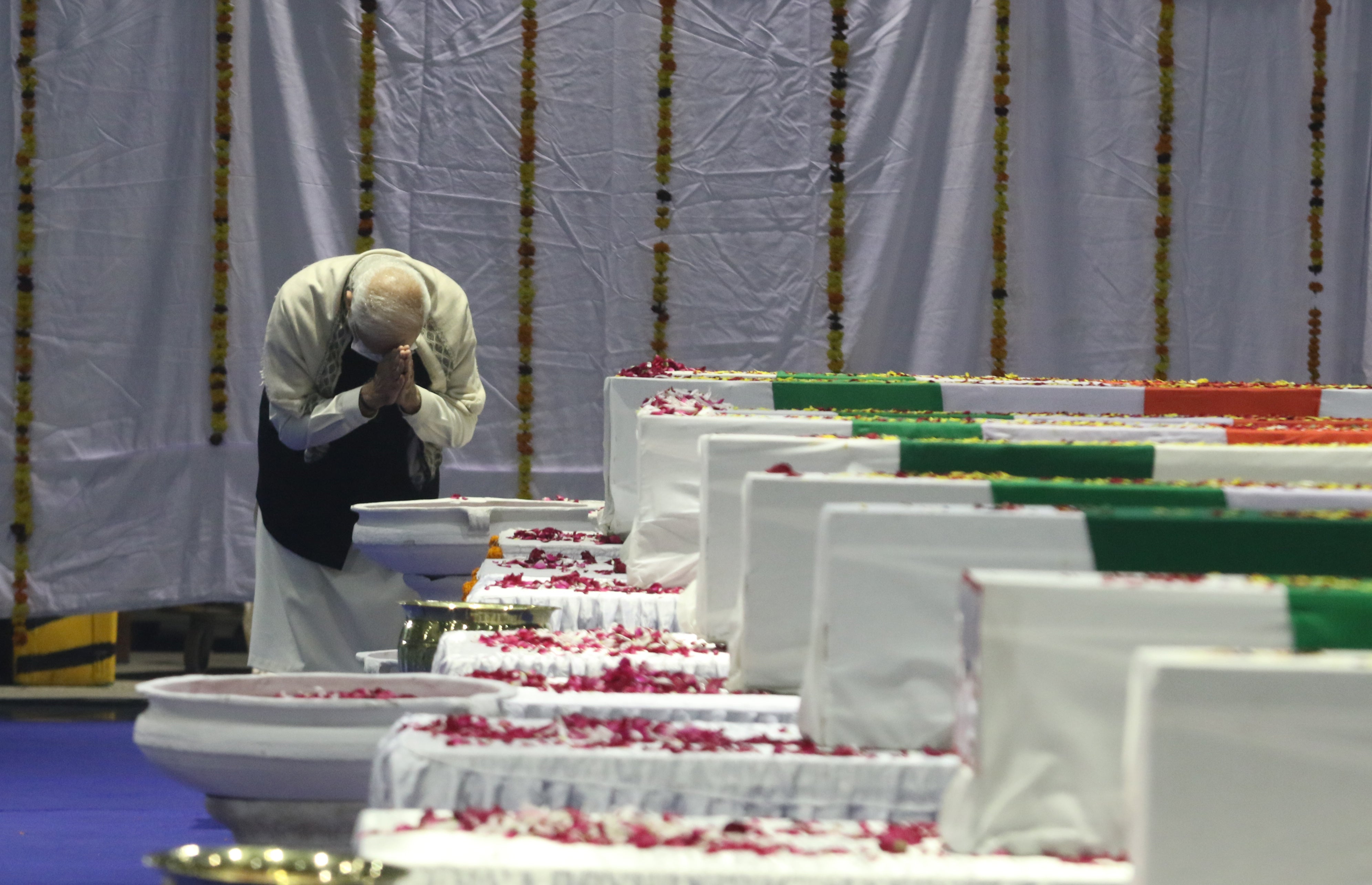 India’s prime minister Narendra Modi pays tributes in front of the coffins of the country’s top military official and 12 others
