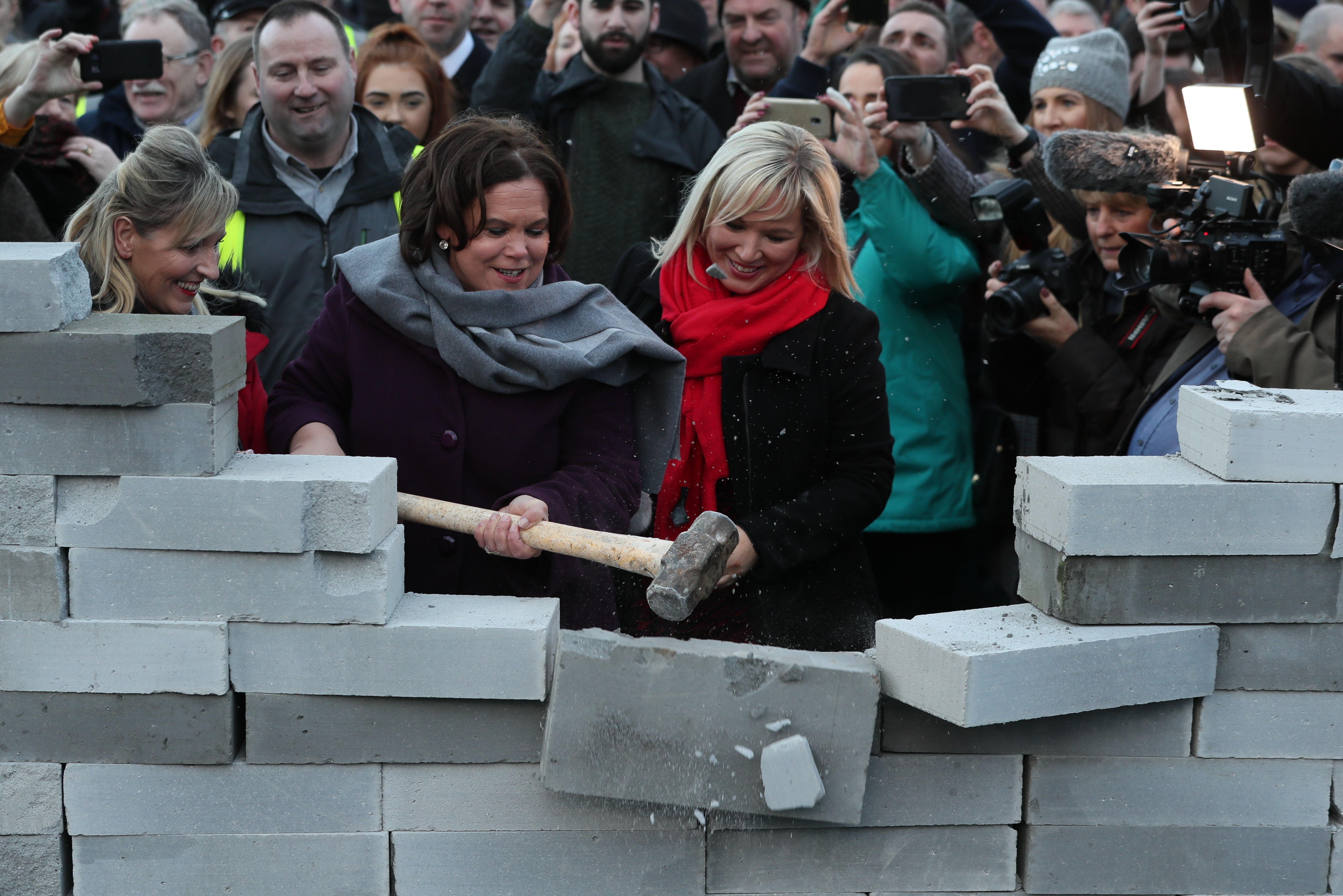 Sinn Fein leader Mary Lou McDonald and deputy leader Michelle O’Neill knock down a symbolic wall that was built as part of an anti-Brexit rally at the Irish border near Carrickcarnan, Co Louth (Brian Lawless/PA)