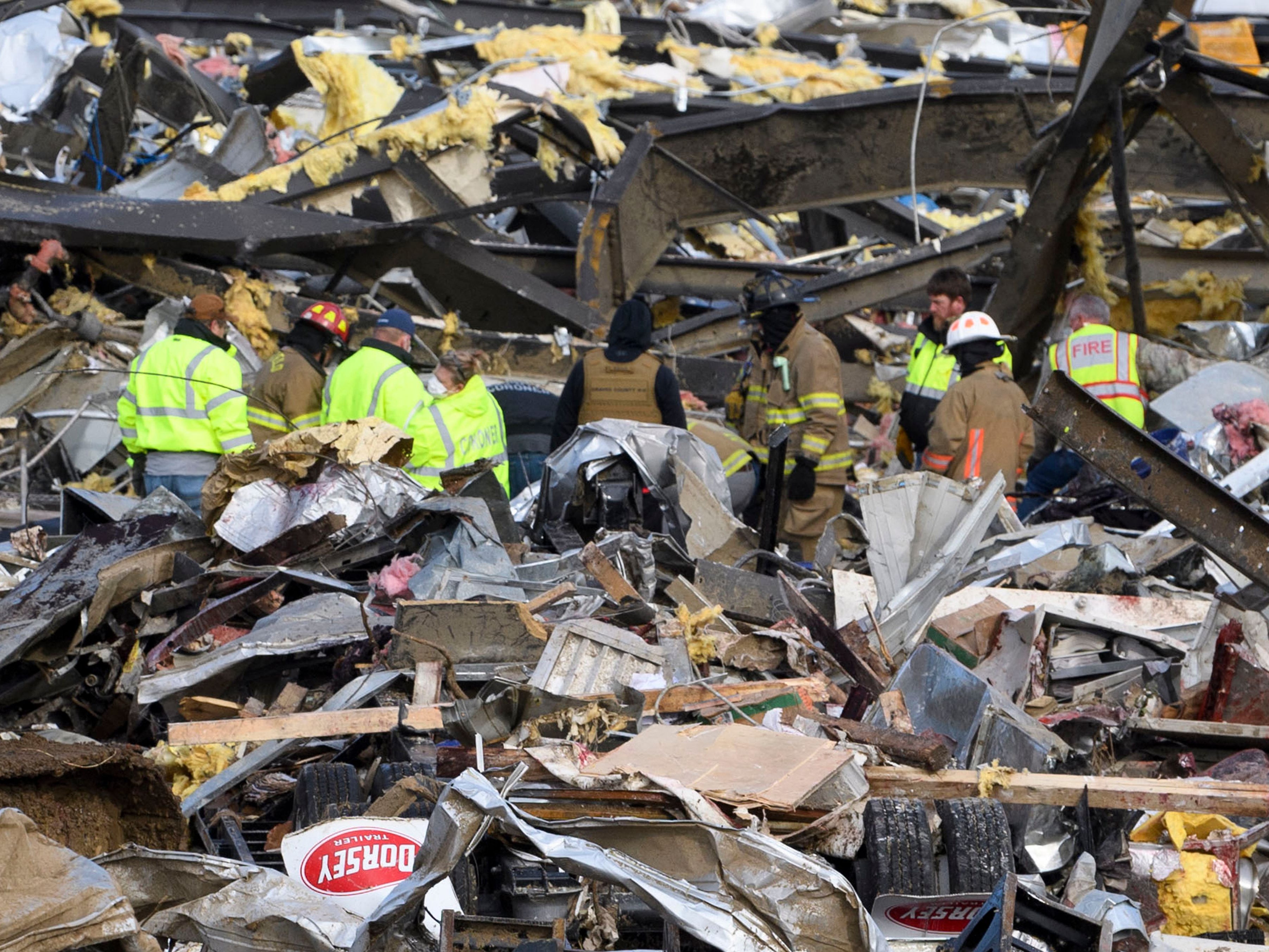 Emergency workers search what is left of the Mayfield Consumer Products Candle Factory after it was destroyed by a tornado in Mayfield, Kentucky, on December 11, 2021