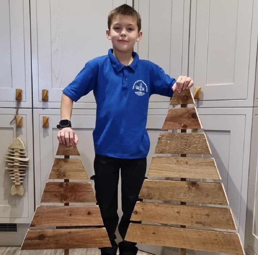 Nine-year-old entrepreneur Noah Last is brightening up his village in Suffolk by selling hand-crafted wooden Christmas trees (Michelle Last/PA)