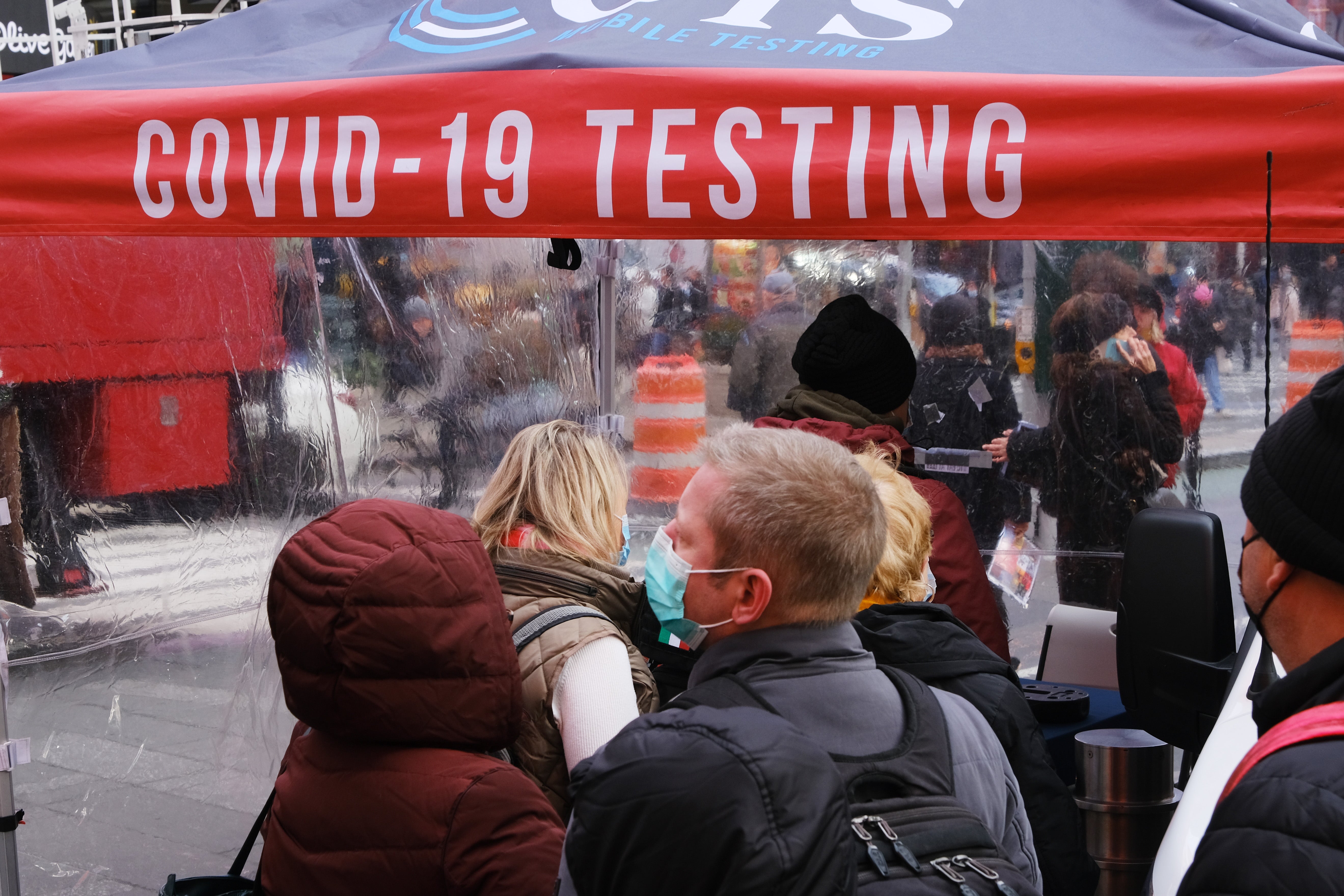 People wait in line to get tested for Covid at a testing facility at Times Square on 9 December 2021