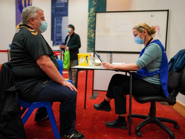 <p>A person waits for their vaccine at a clinic in Newcastle</p>