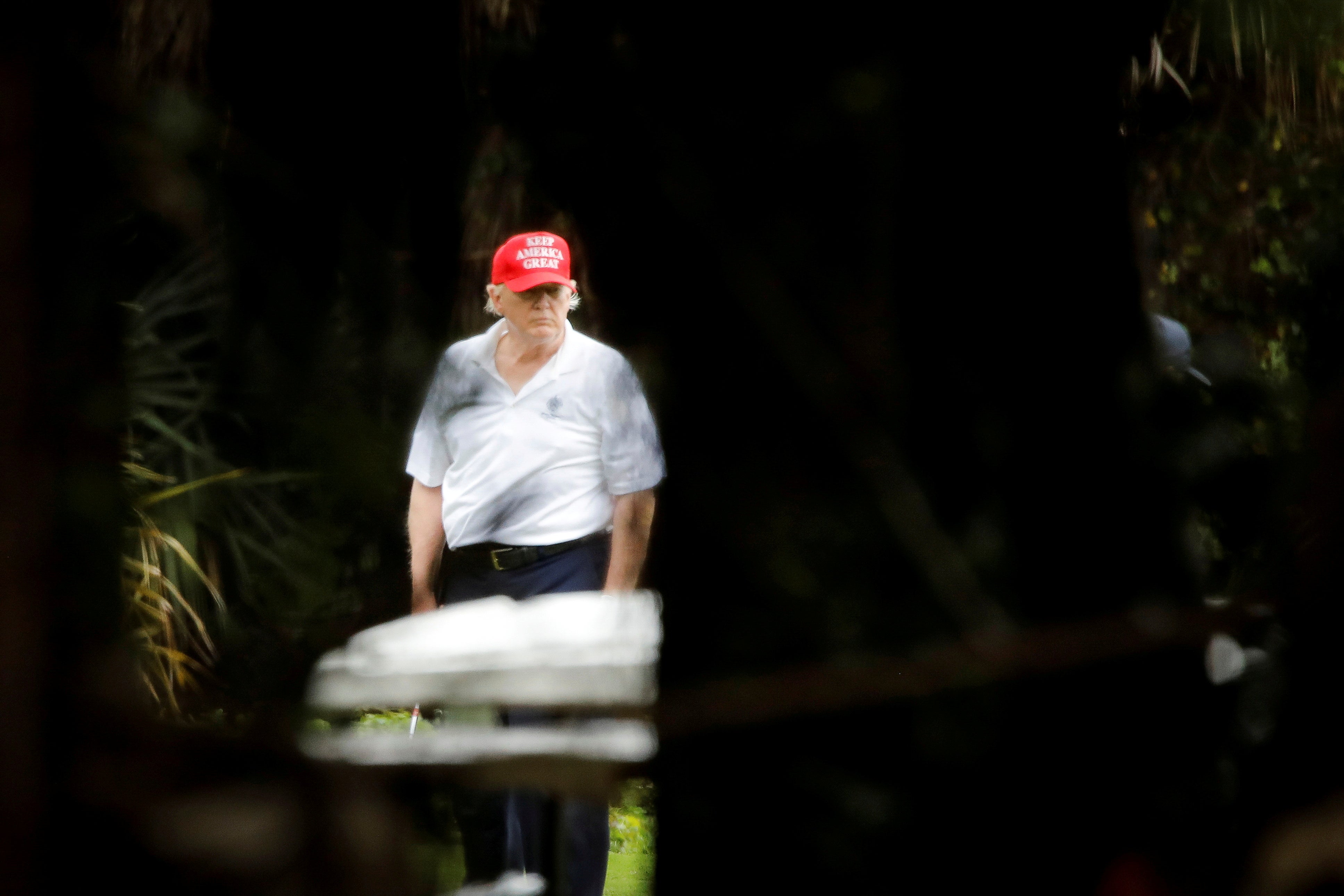 The US president playing golf at the Trump International Golf Club in West Palm Beach, Florida