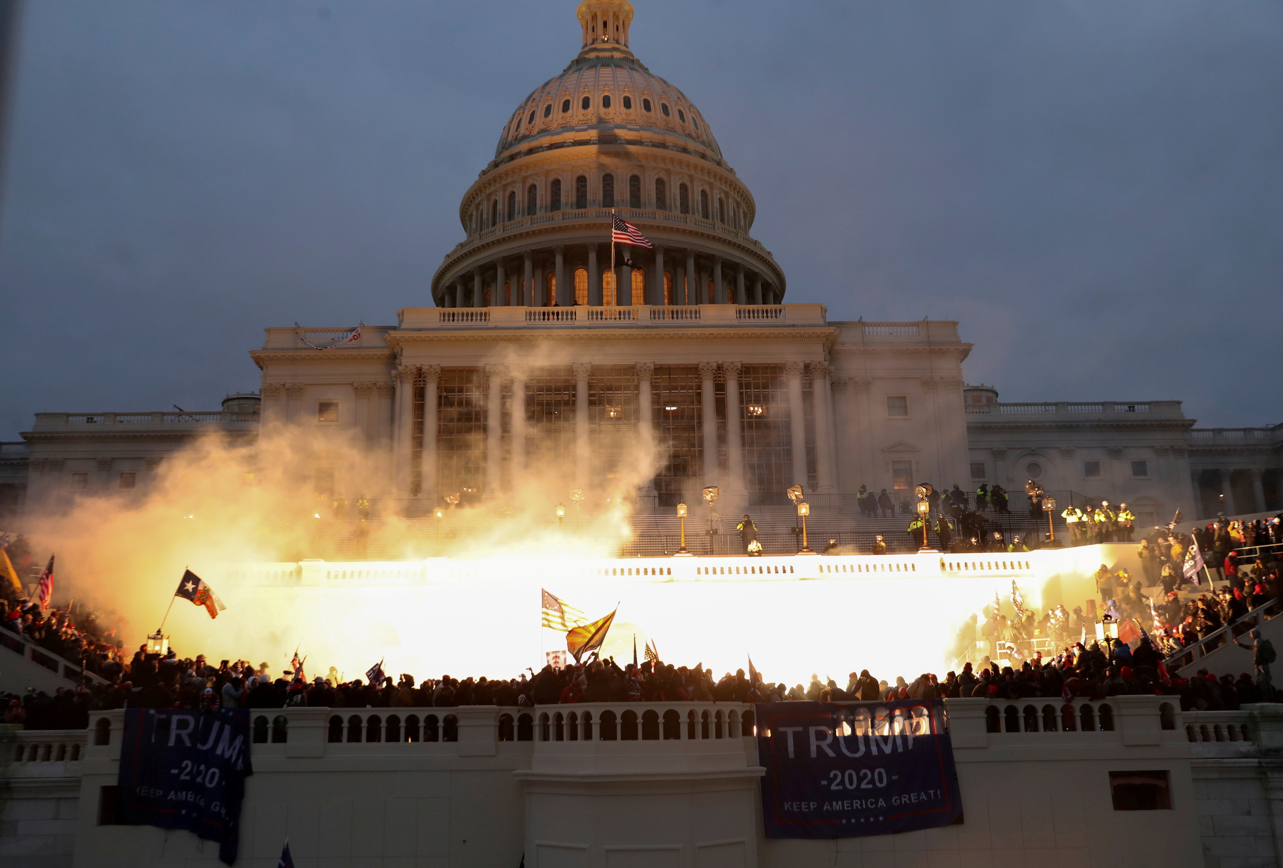 A photo captures an explosion caused by a police munition in front of the US Capitol building on 6 January