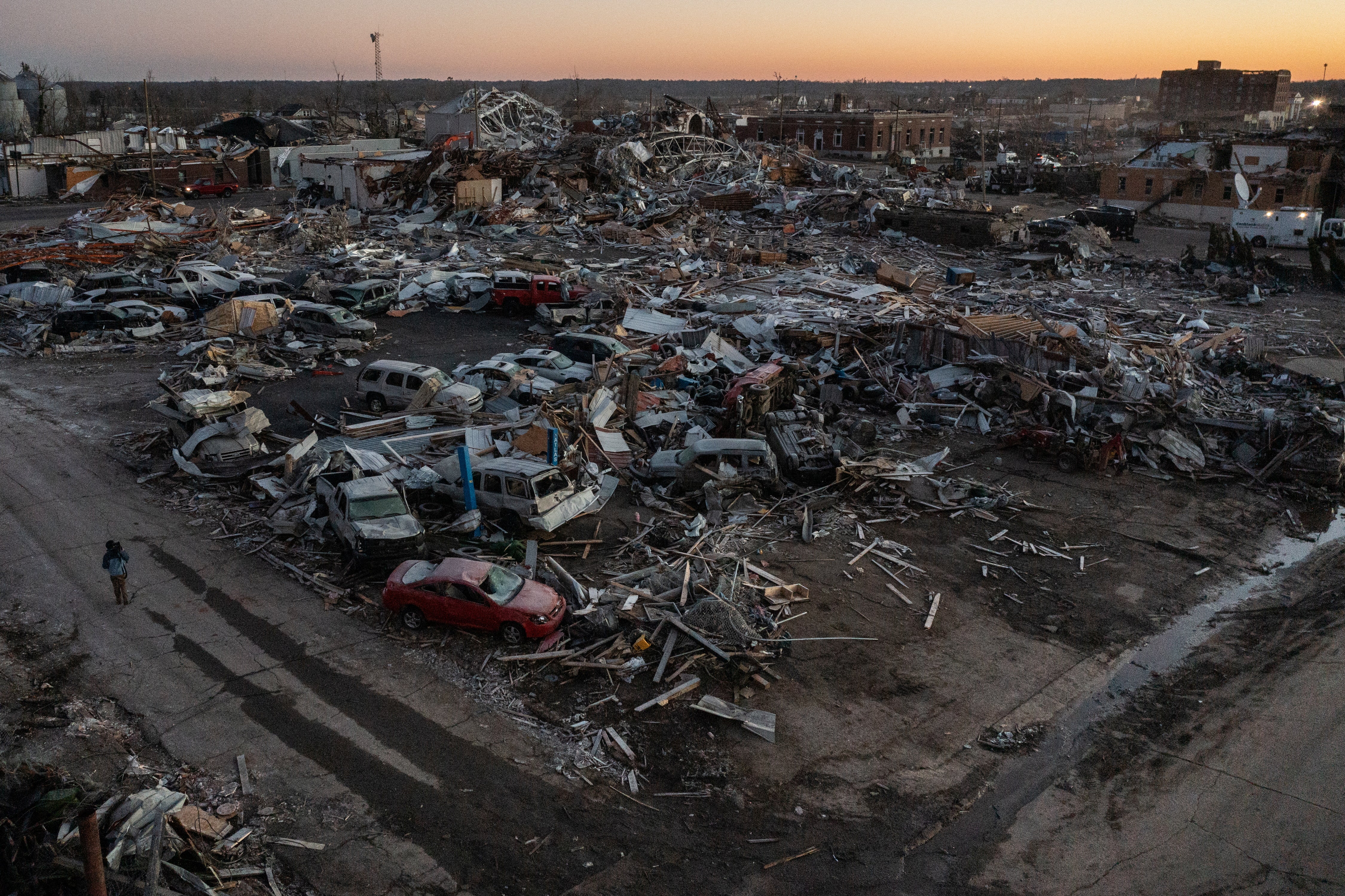 A man walks past destroyed residences and businesses in the aftermath of a tornado in the city center of Mayfield, Kentucky, U.S. December 13, 2021