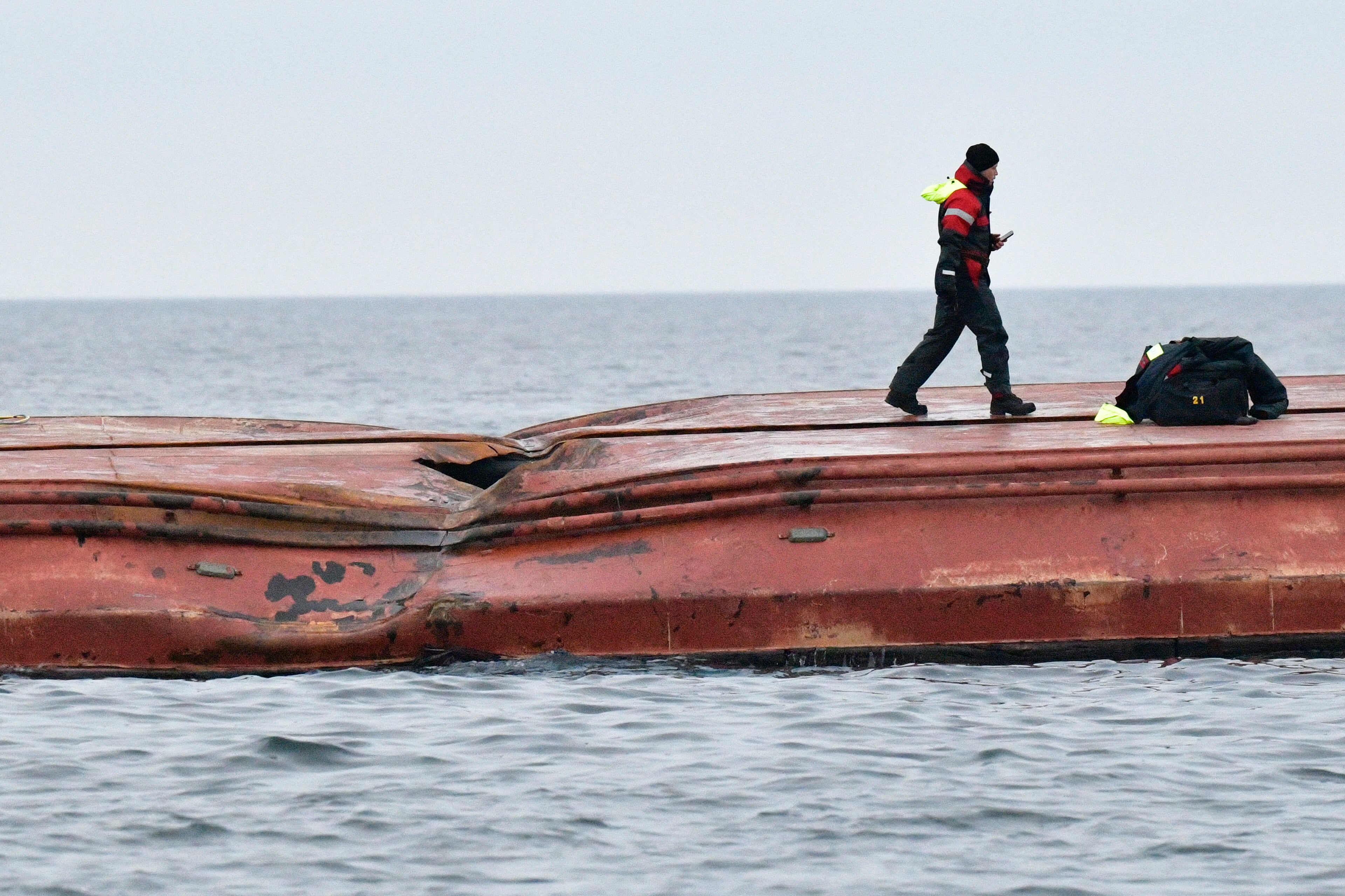 Divers work on the capsized Danish cargo ship Karin Hoej, right, after it collided with British cargo vessel Scot Carrier in the Baltic Sea
