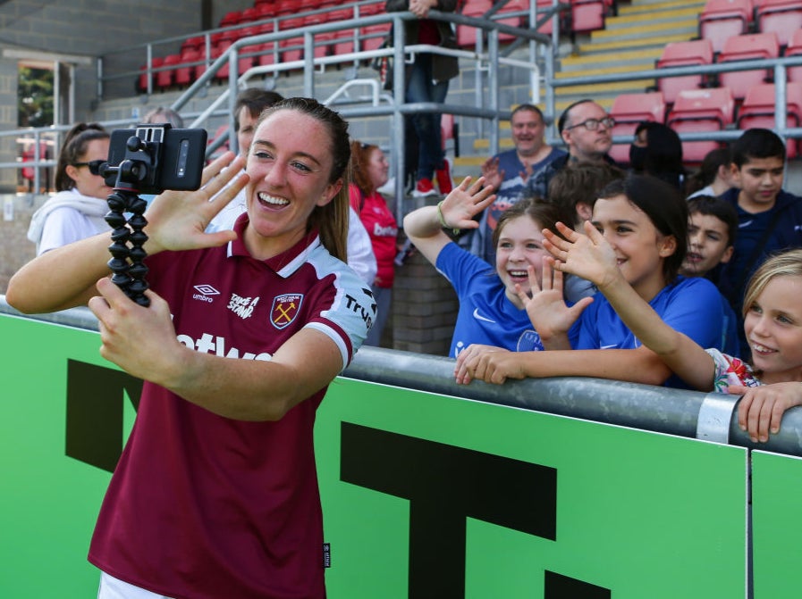 Lisa Evans takes a photo with young fans after West Ham’s WSL match against Aston Villa